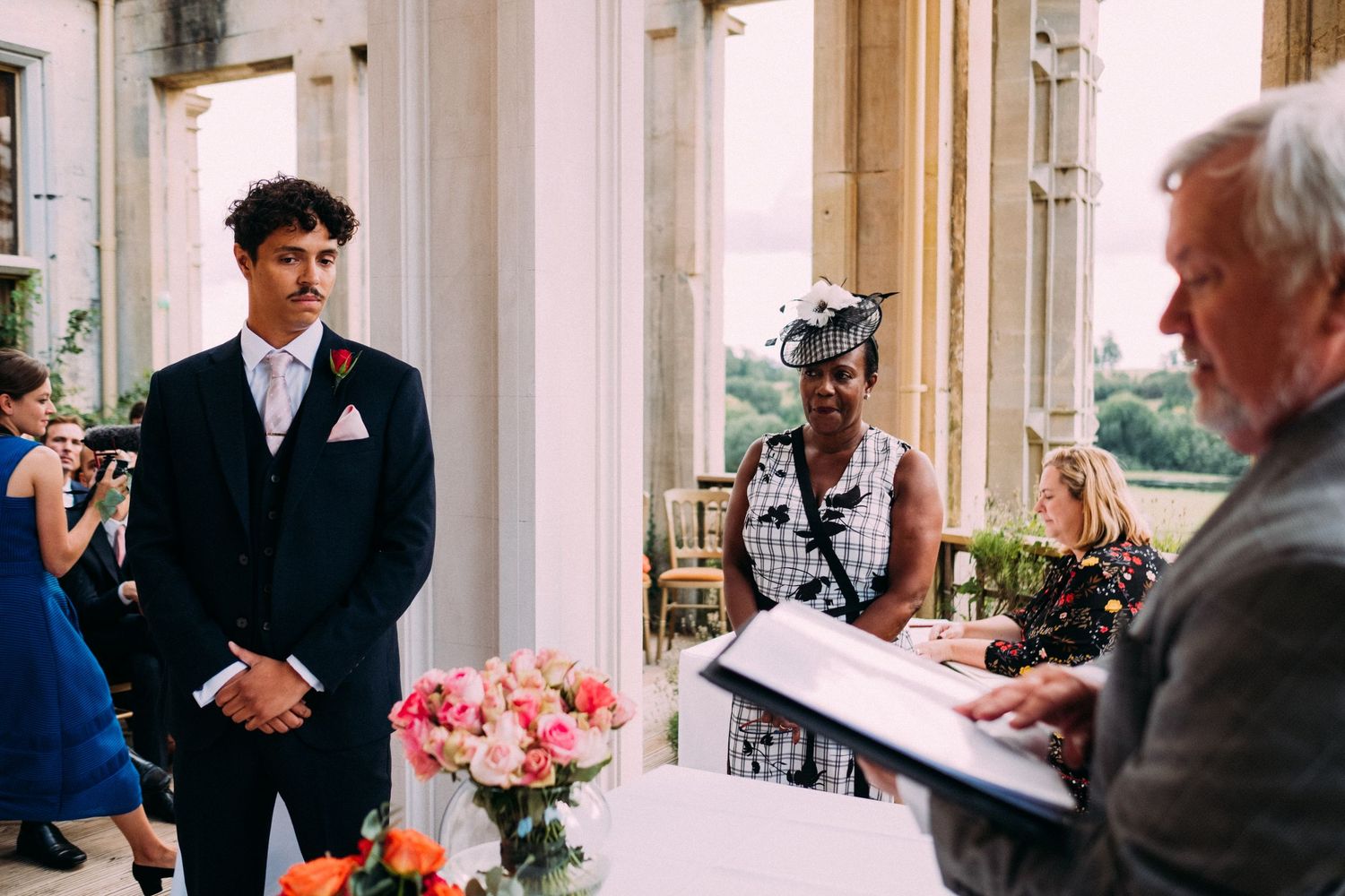 Guests gather in a grand columned hallway with natural light streaming through windows.
