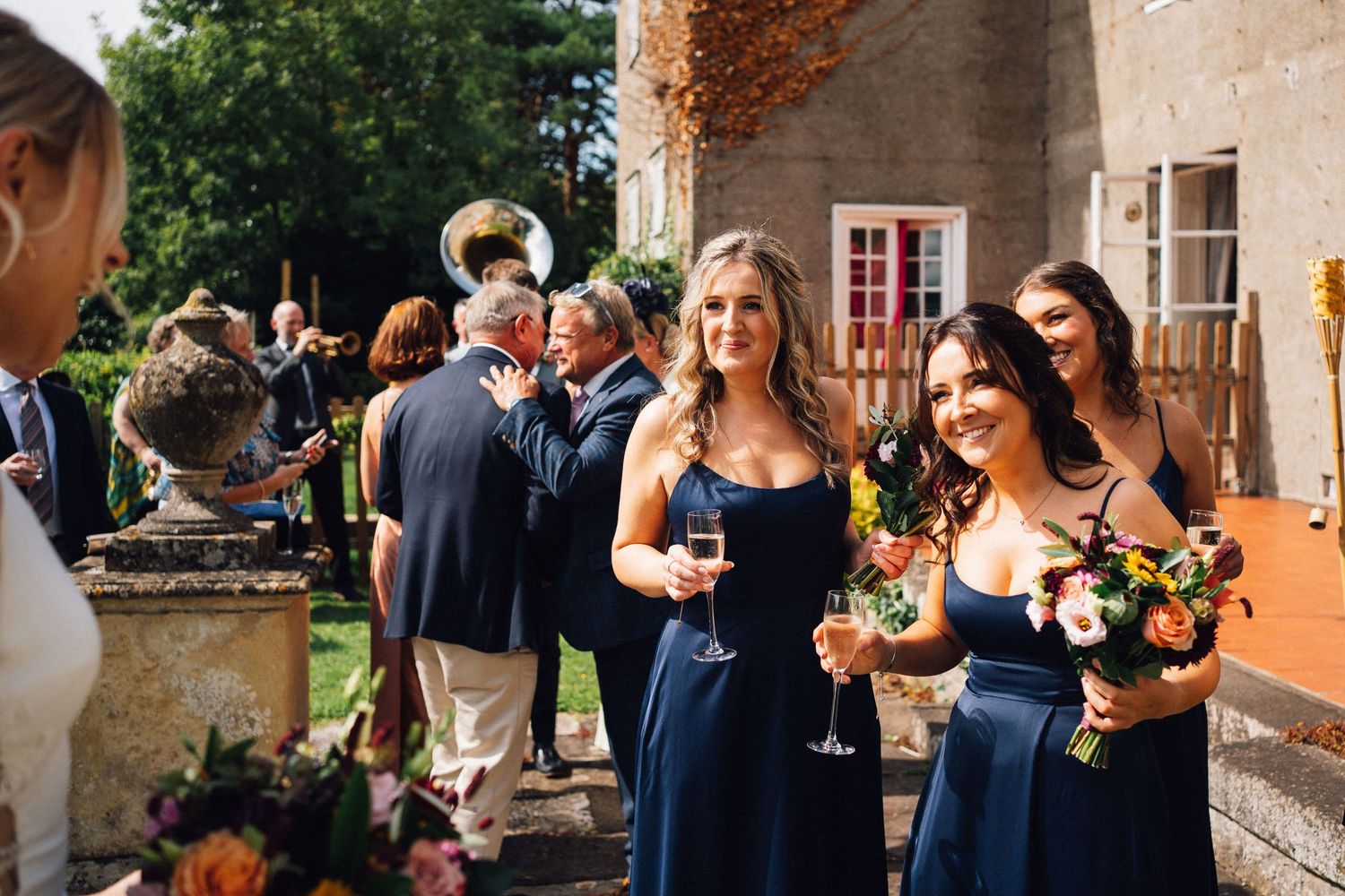 Wedding guests enjoy outdoor reception at rustic countryside venue.