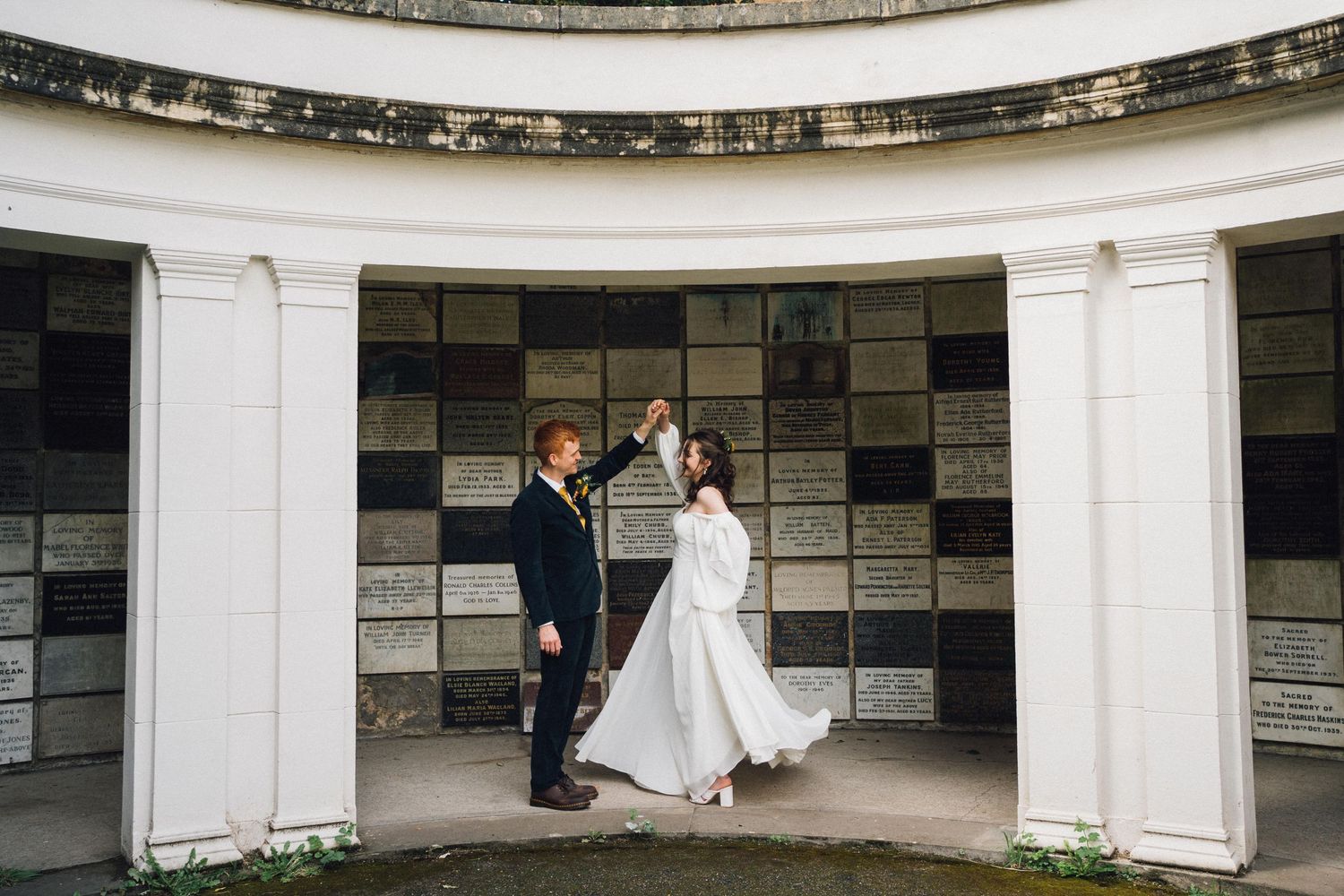 White stone colonnade with classical architecture creates an elegant wedding venue backdrop.