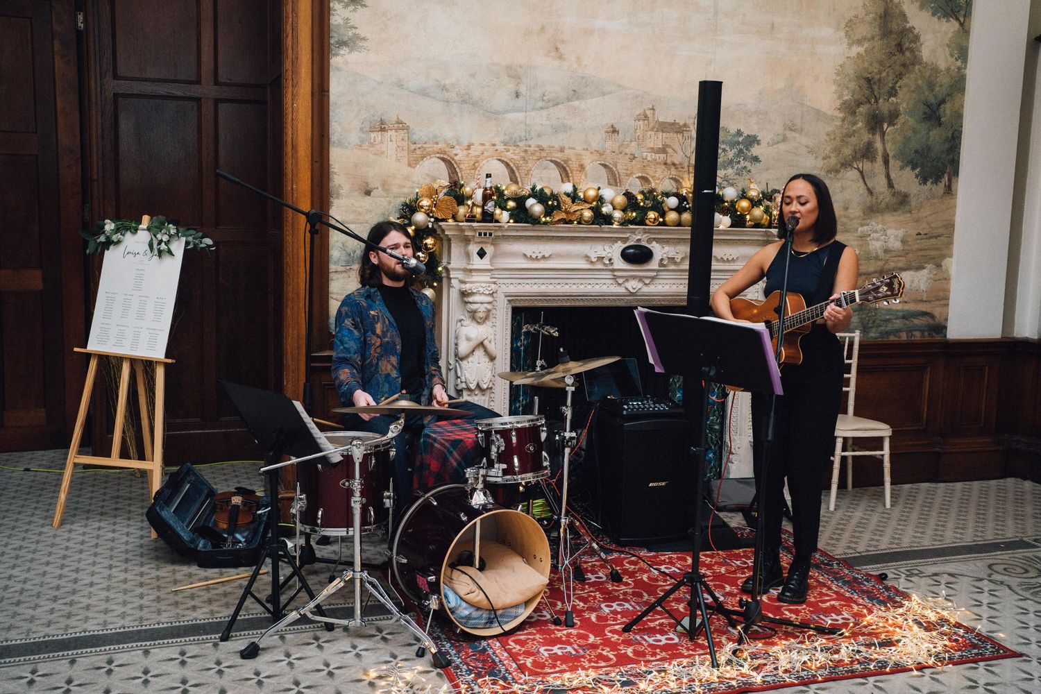 Live band performs at an elegant wedding reception with classic stone wall backdrop.
