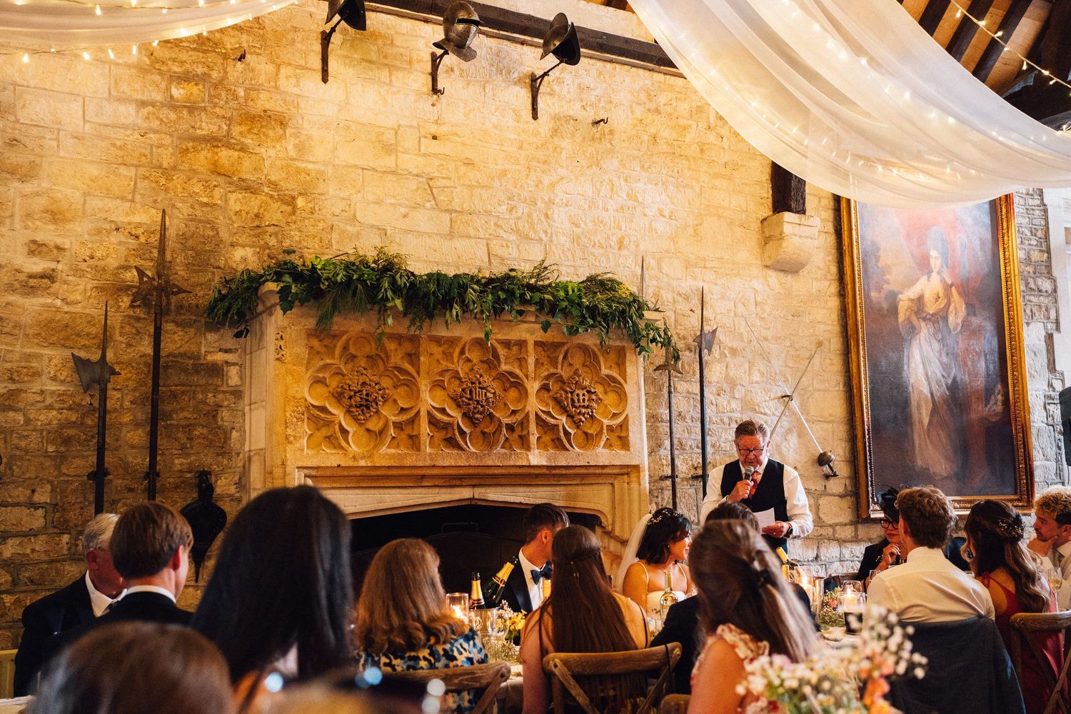 Elegant indoor wedding reception in a rustic stone venue with warm lighting.