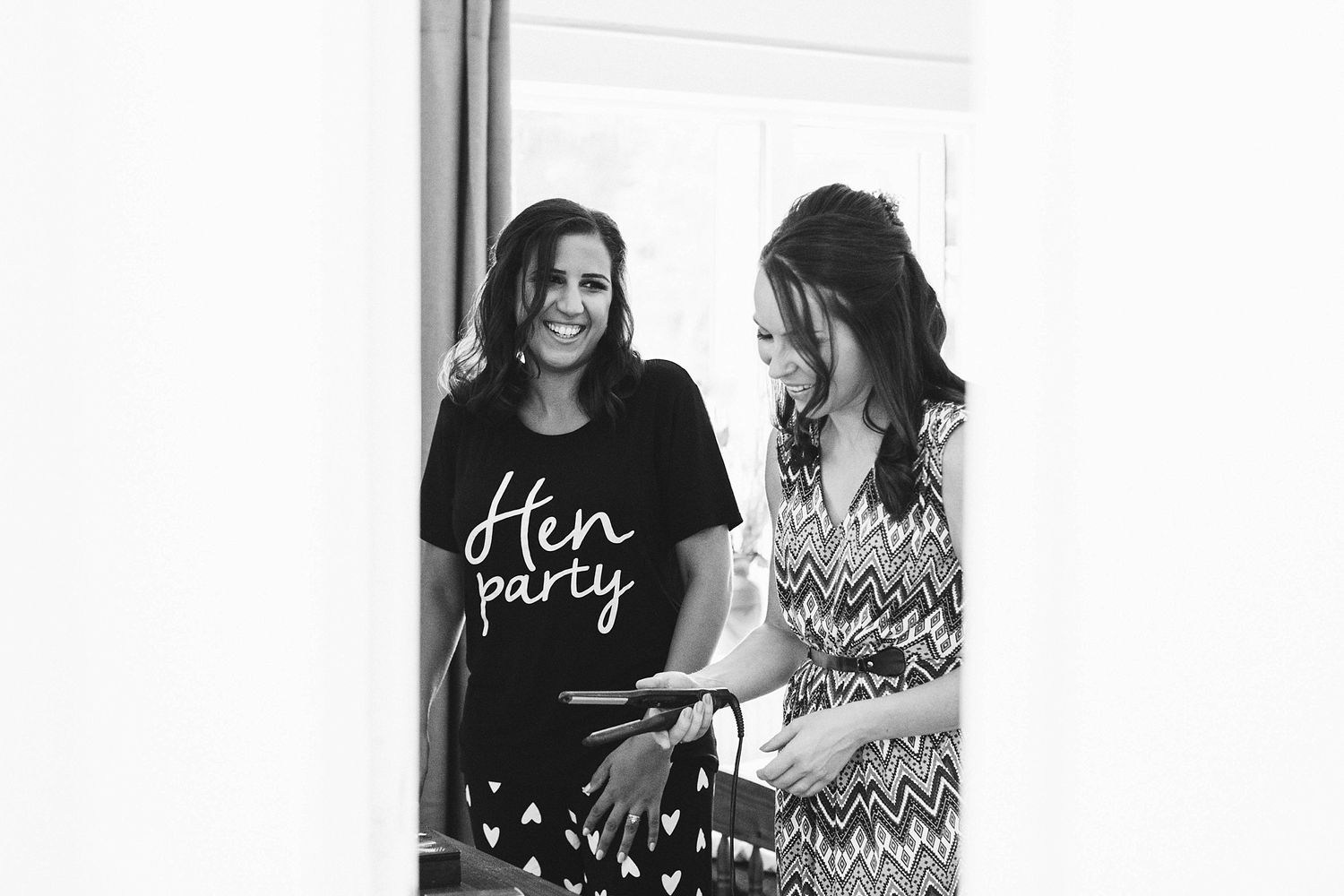 Friends gathering and laughing together during wedding preparations.