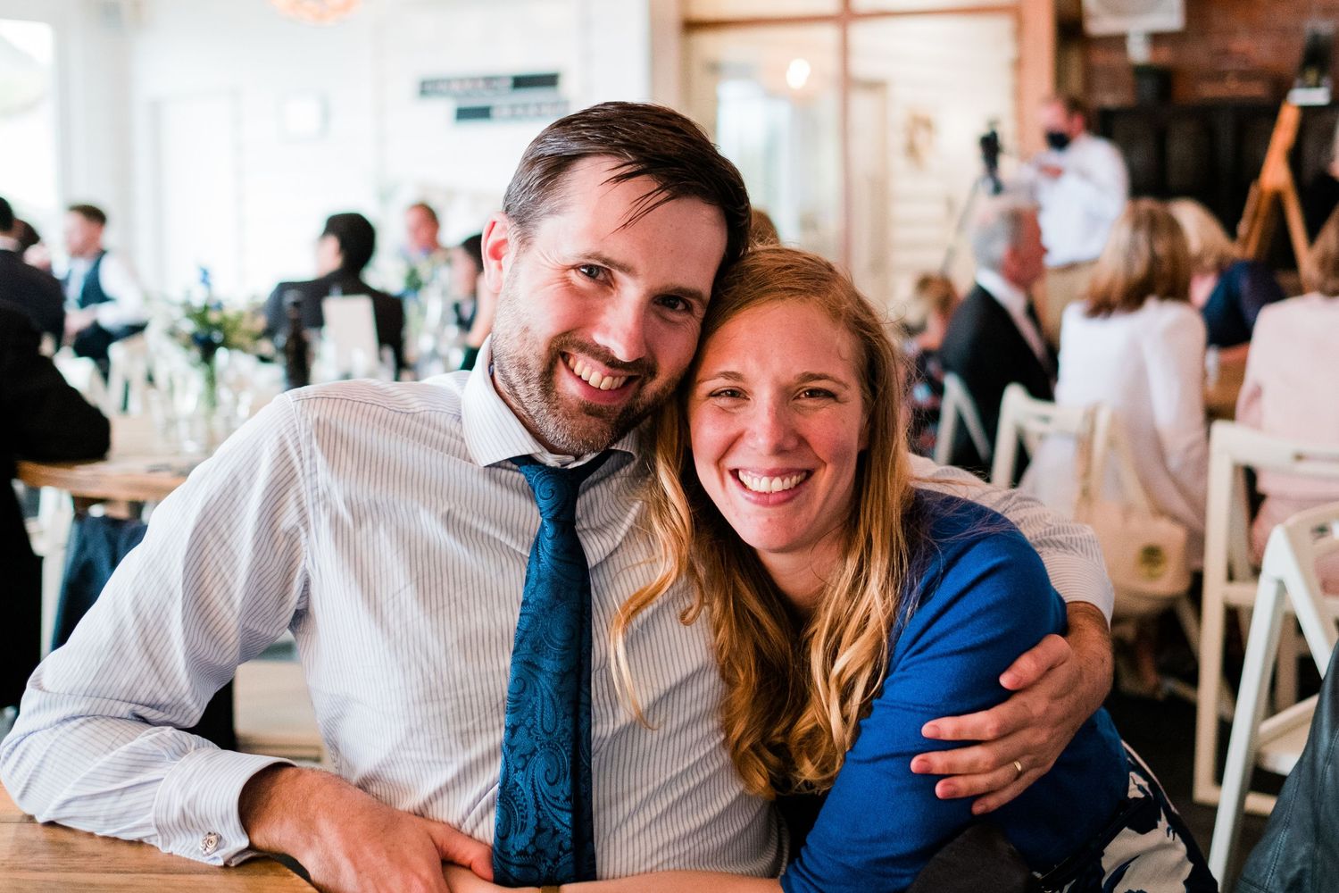 Candid moments between guests at an indoor celebration with natural lighting.