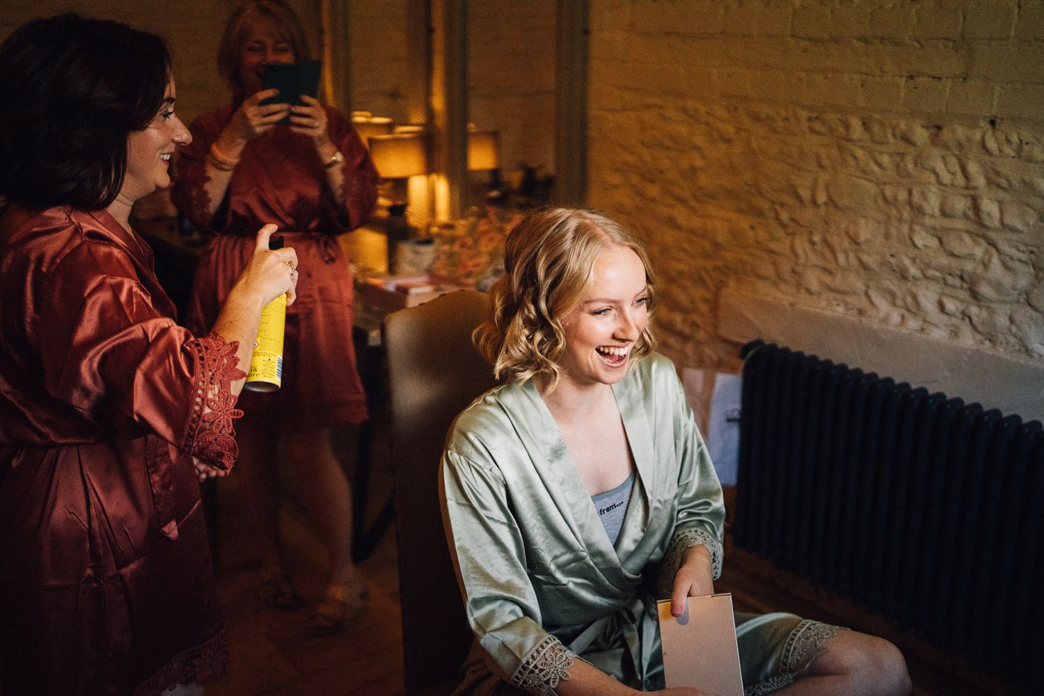 People celebrating and socializing at a dimly lit indoor party with drinks and laughter.