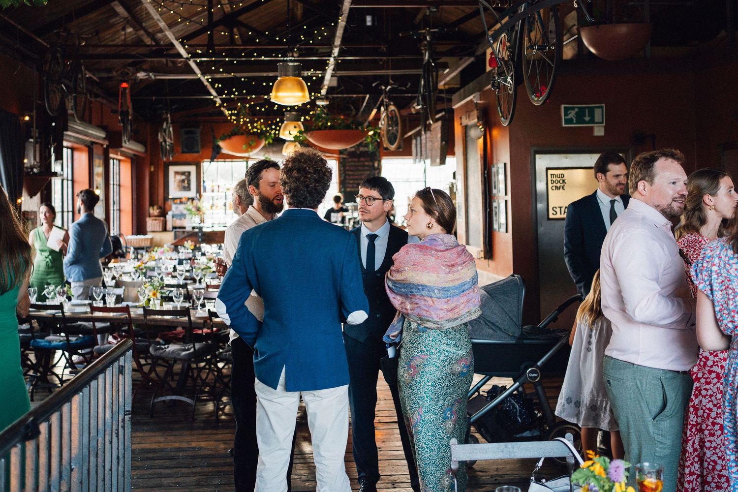 Guests enjoying a wedding celebration inside a cozy pub-style venue with warm lighting.