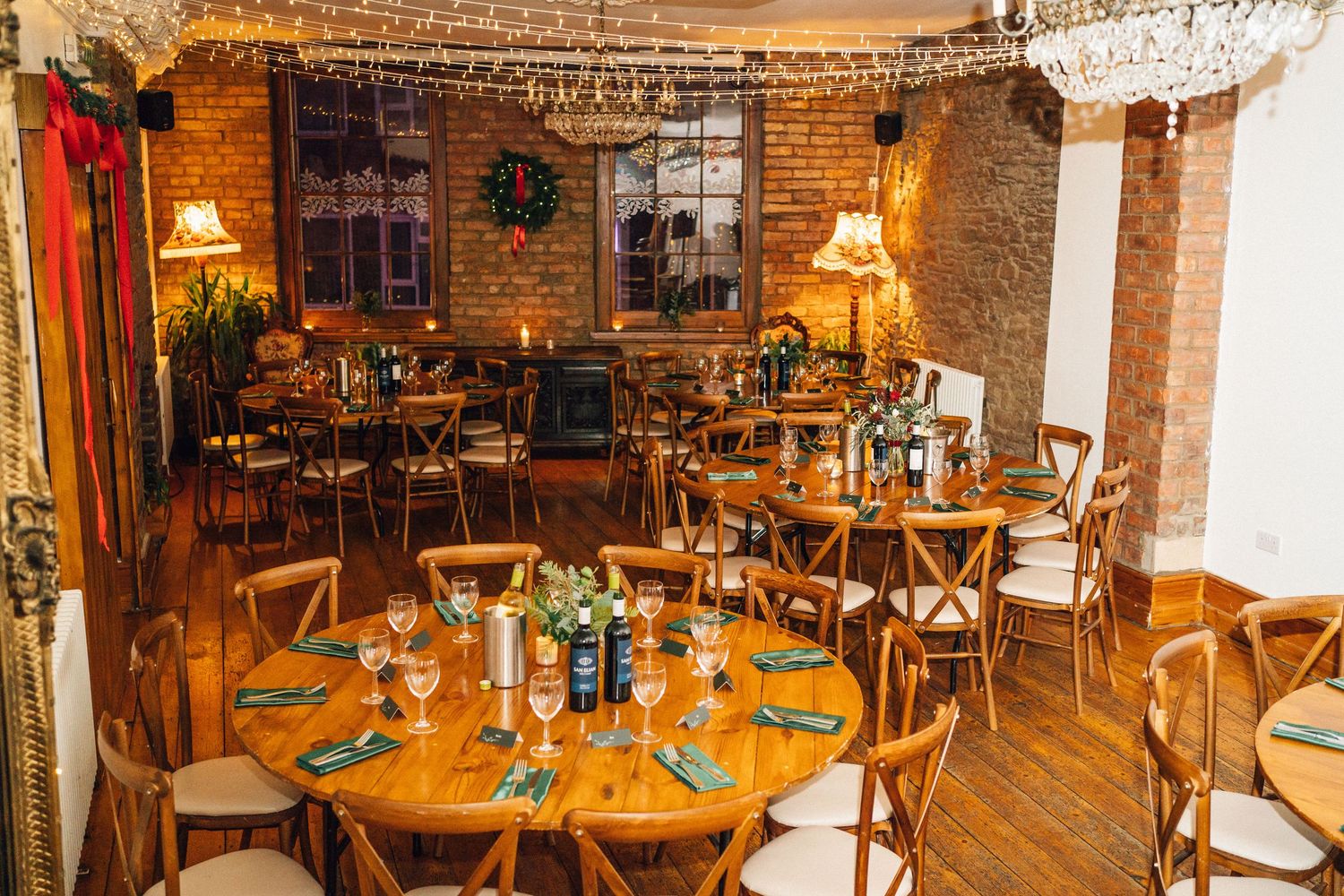 A cozy restaurant interior with exposed brick walls, wooden tables, and warm lighting creating an inviting atmosphere.