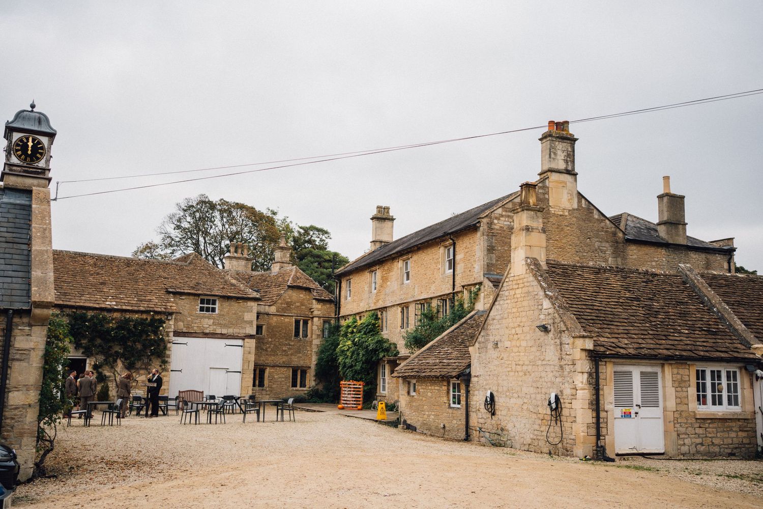 Row of traditional limestone cottages and buildings along a narrow street in an English village.