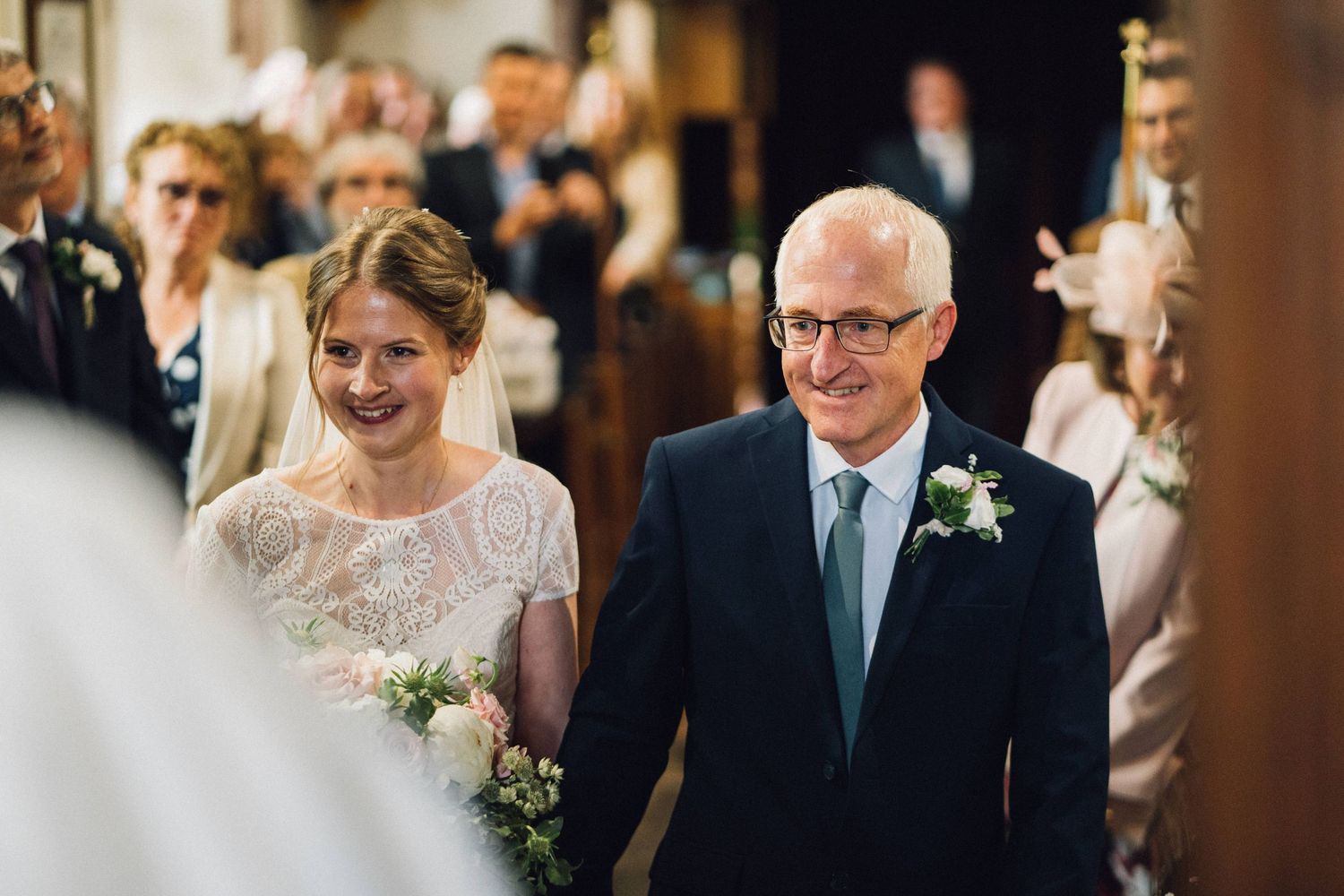 Wedding ceremony taking place in traditional church with guests seated.