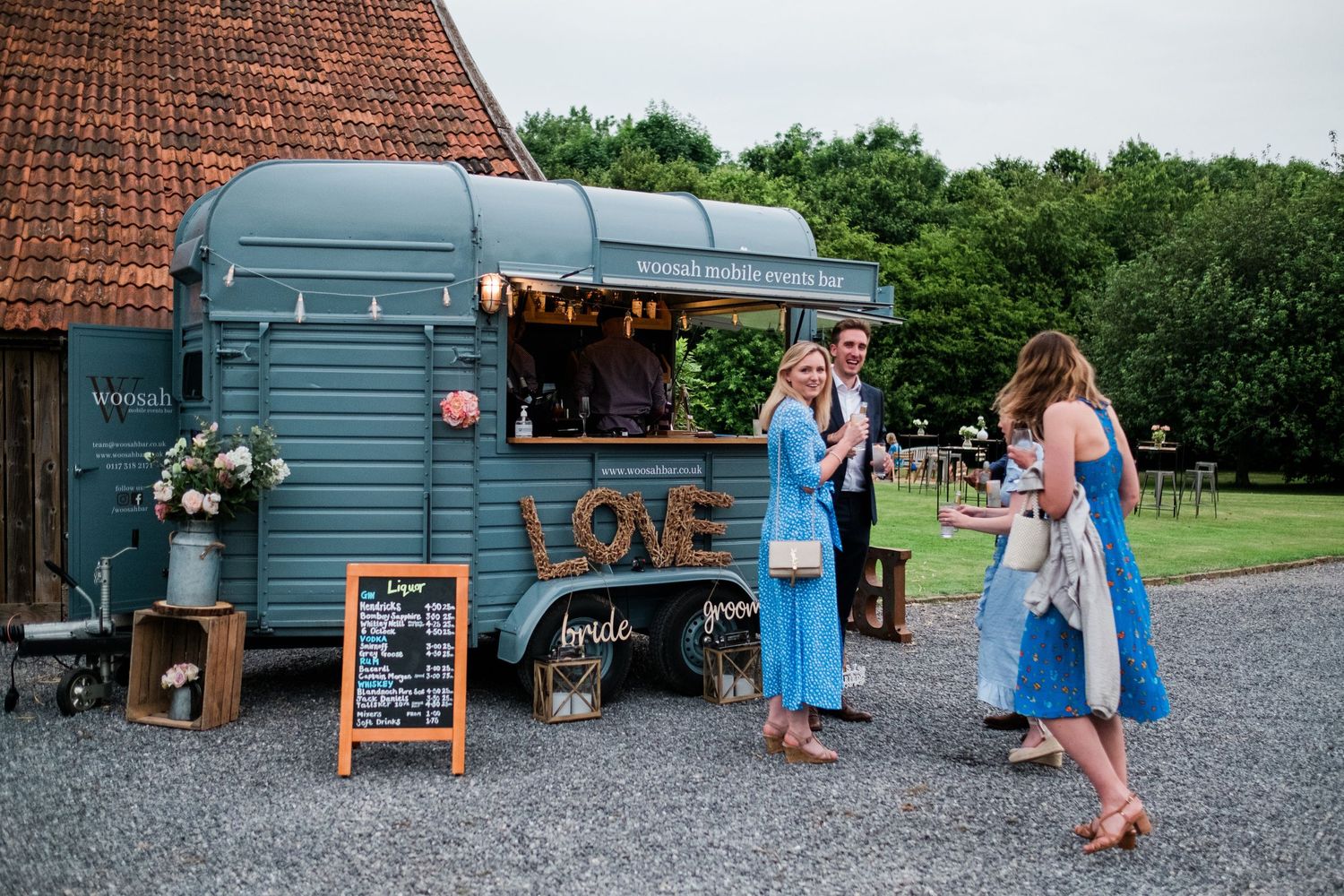 Rustic barn venue exterior with blue doors and gravel pathway during a wedding.
