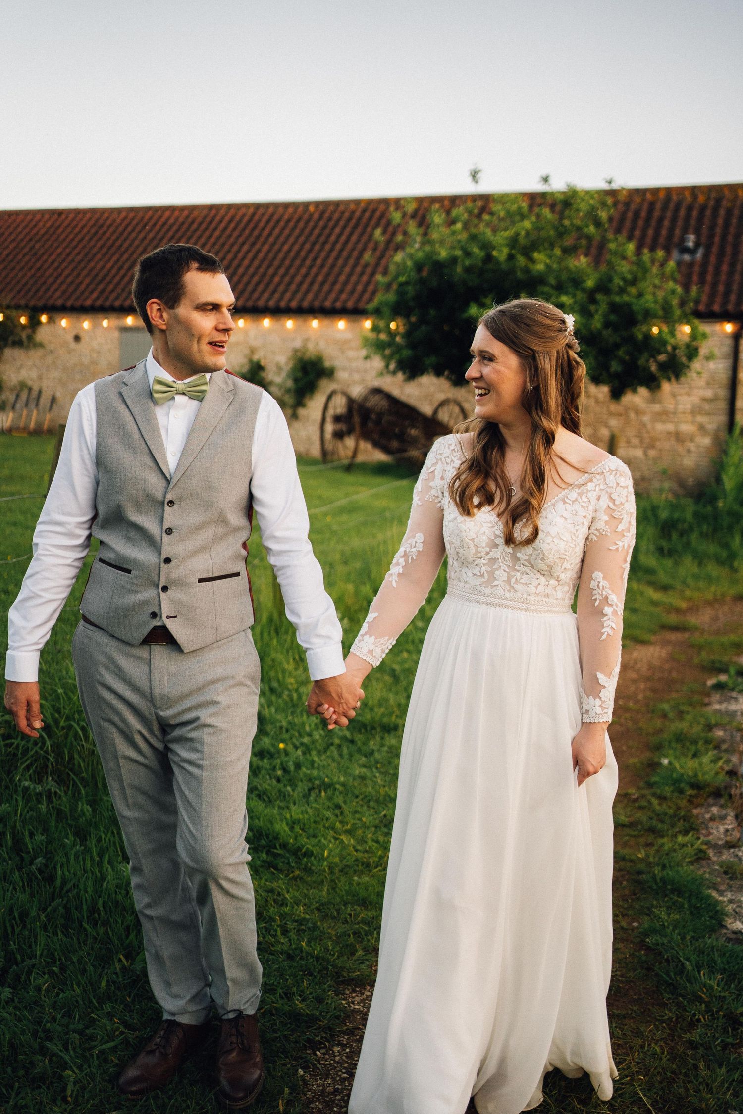 Candid wedding moments photographed in outdoor setting with rustic stone building backdrop.