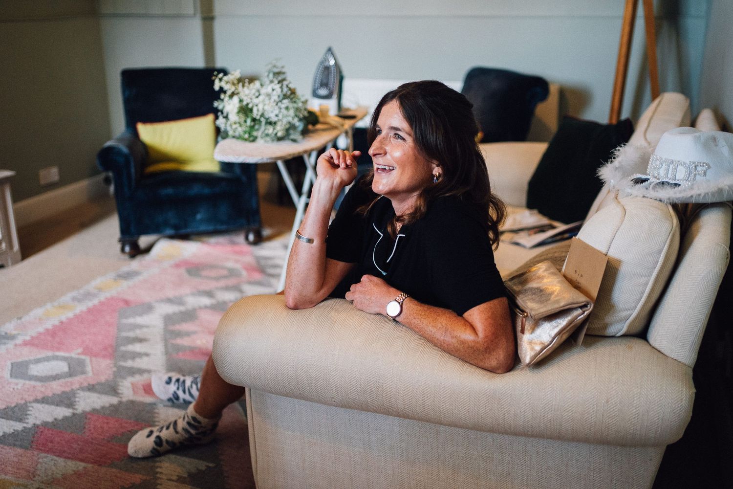 Candid moments captured during wedding preparations on a comfortable grey sofa.