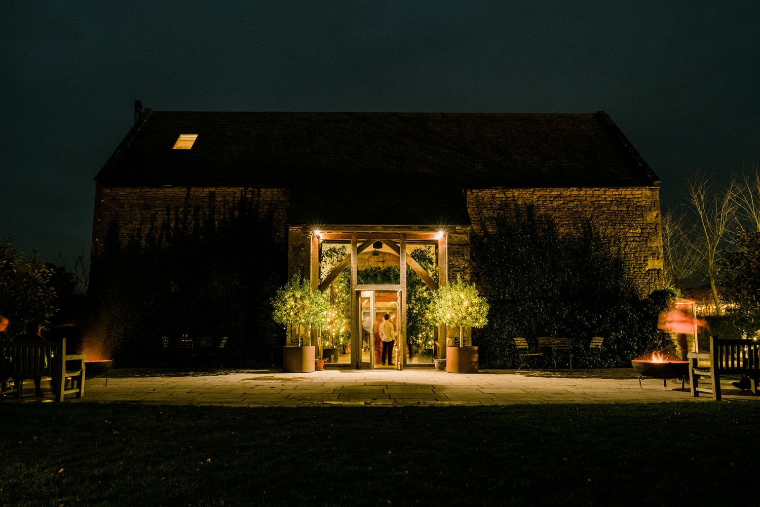 Panoramic night view of illuminated wedding venue buildings and landscape.
