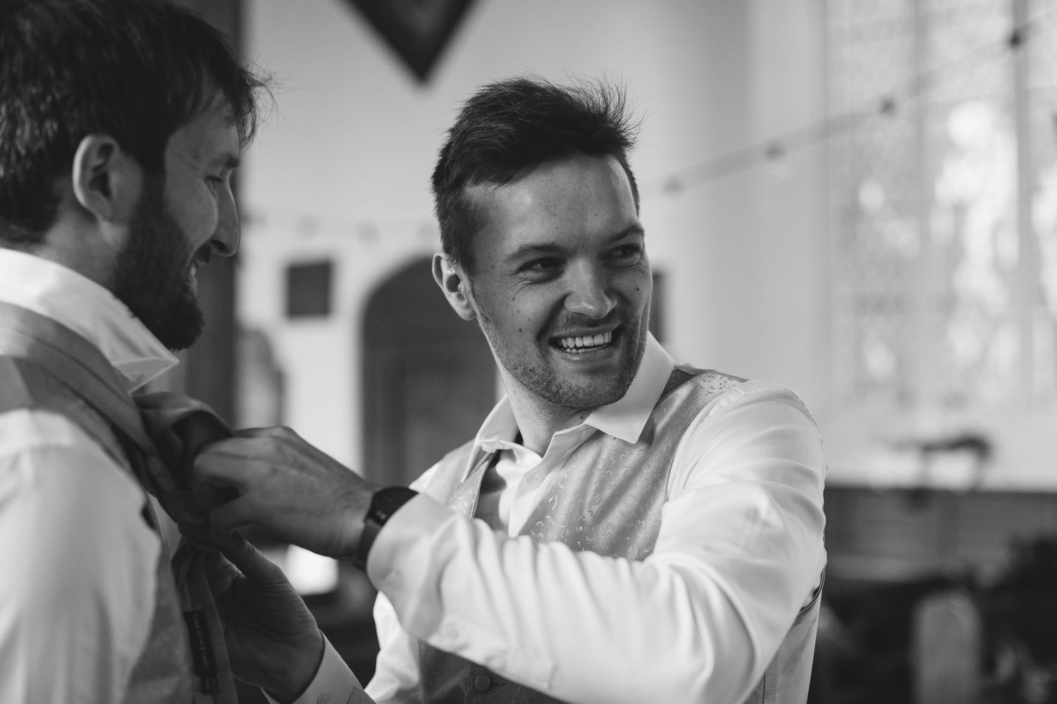 Black and white sequence of joyful candid moments in an indoor setting.