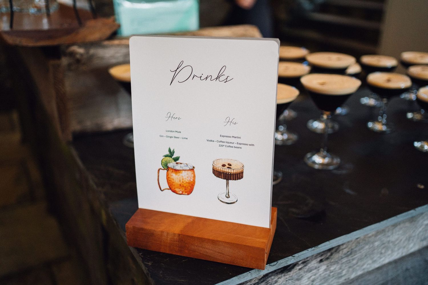 Elegant wedding reception table settings with cocktail menu cards and decorative details.