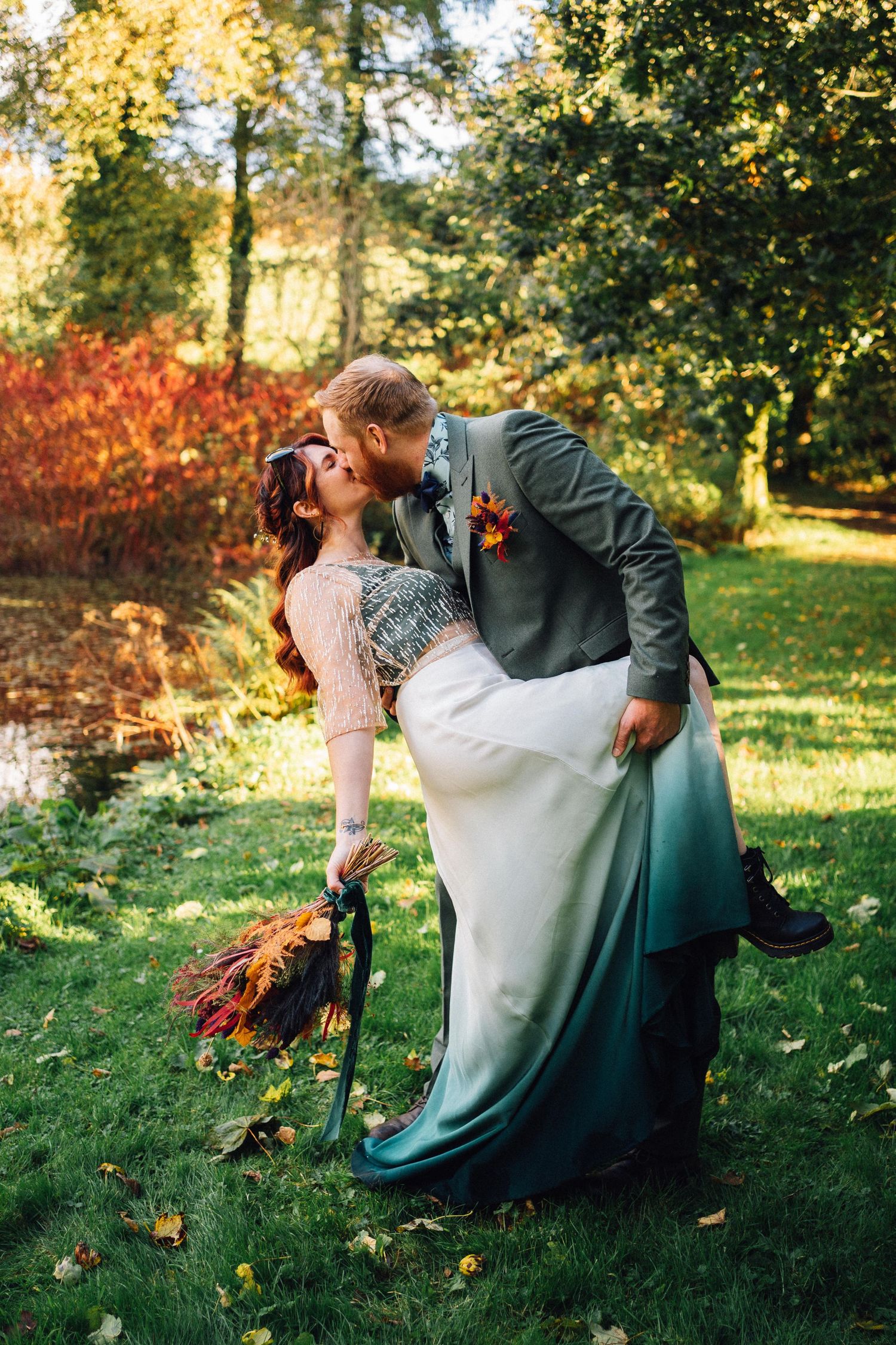 Romantic autumn wedding photos with couple embracing among fallen leaves in golden sunlight.