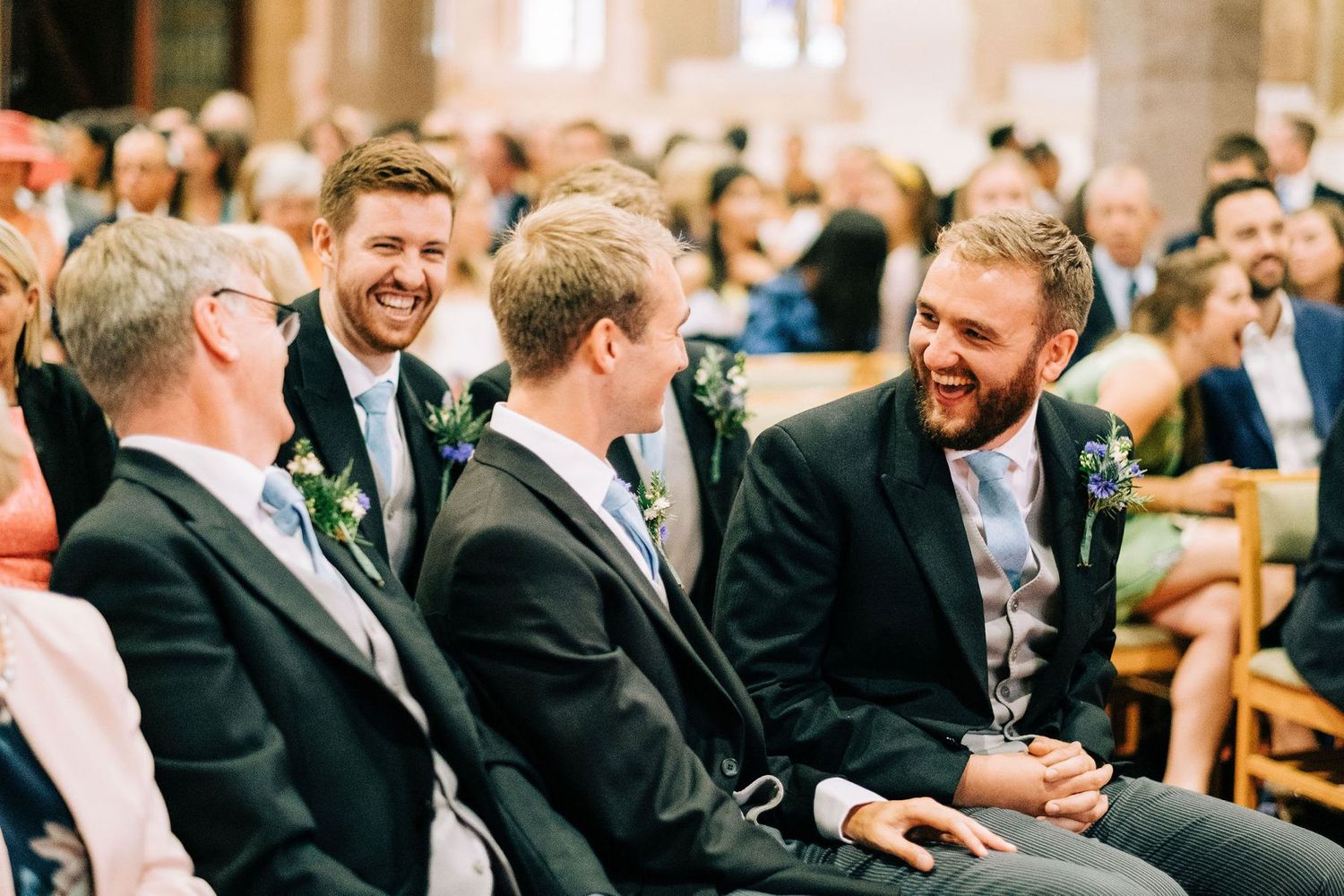 Wedding guests share joyful moments during church ceremony.