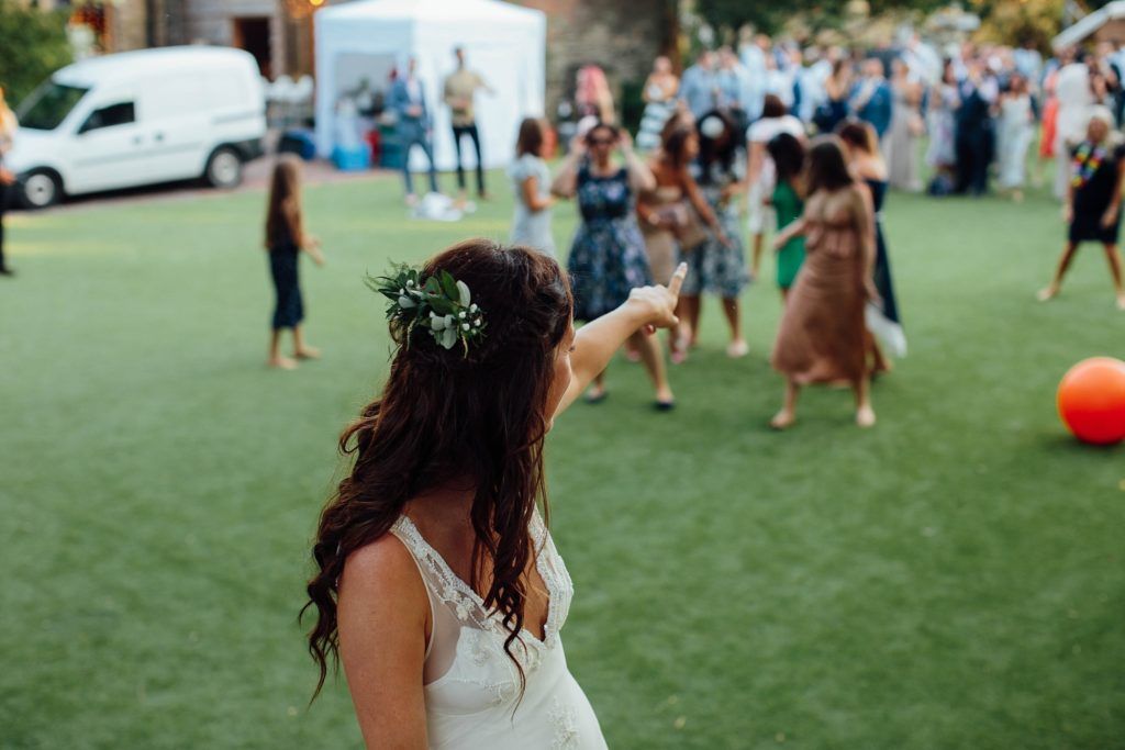 Guests enjoy outdoor lawn games and activities during a summer wedding reception.