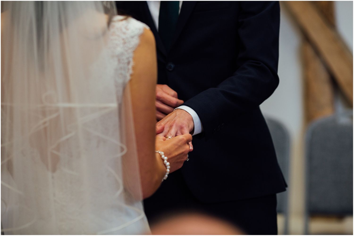 Intimate wedding ceremony moment captured in a barn with natural wood beams.