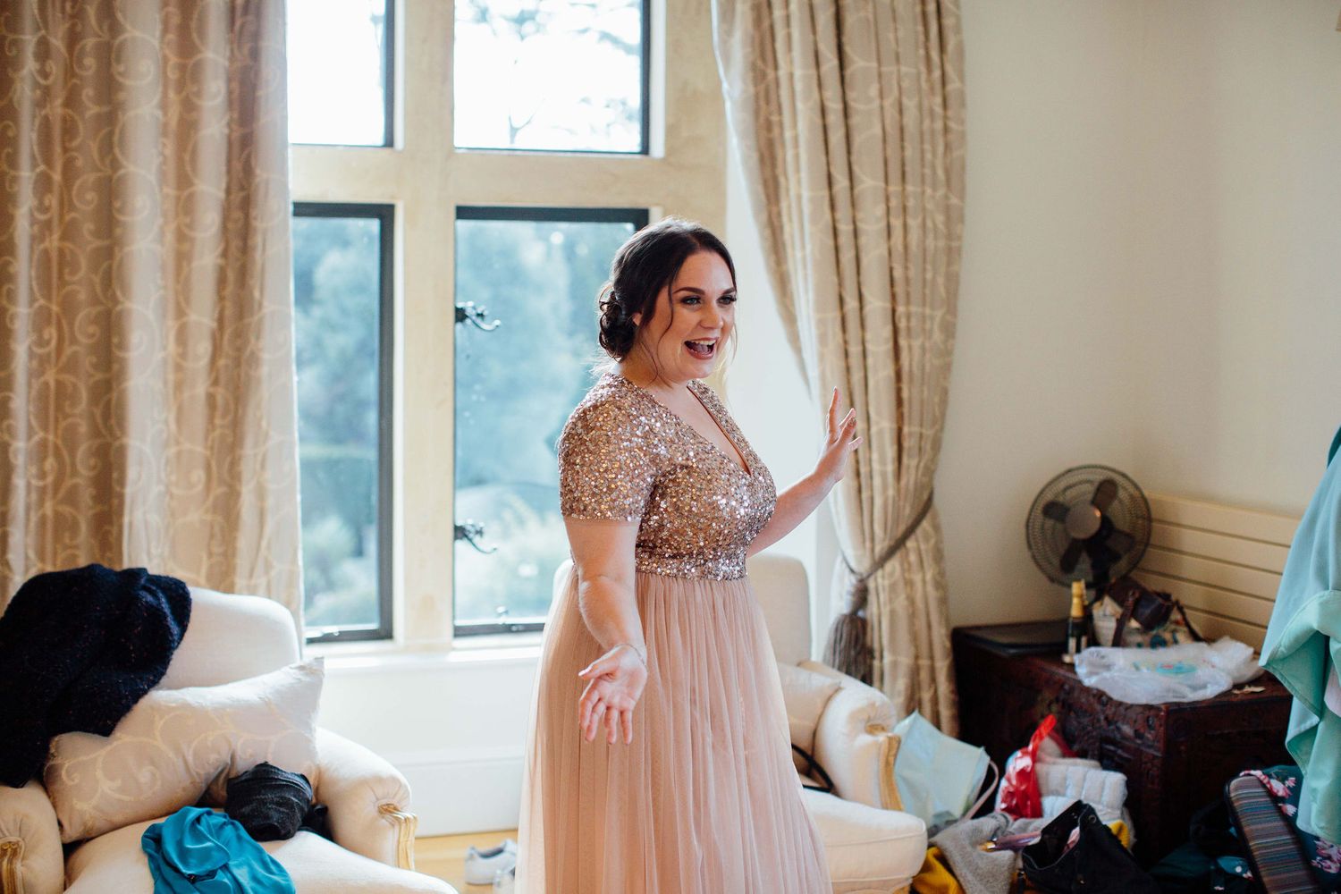 Elegant bridal preparation room with natural light streaming through large windows.