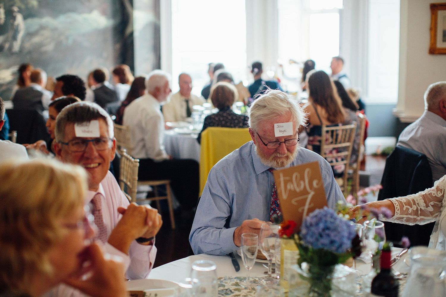 Wedding reception venue with tables set for dining and guests enjoying the celebration.