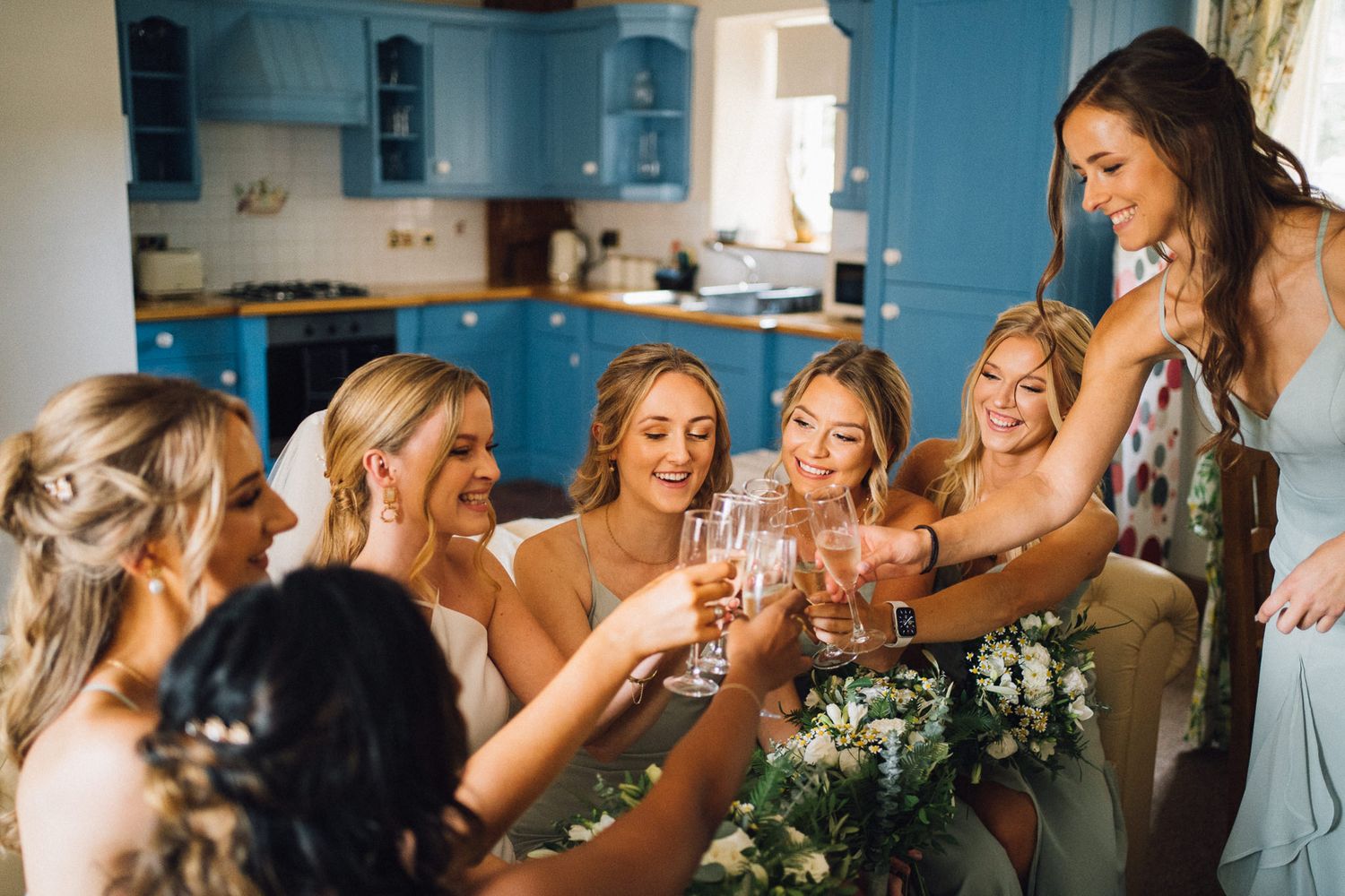 Candid moments of celebration captured in a bright room with blue kitchen cabinets.