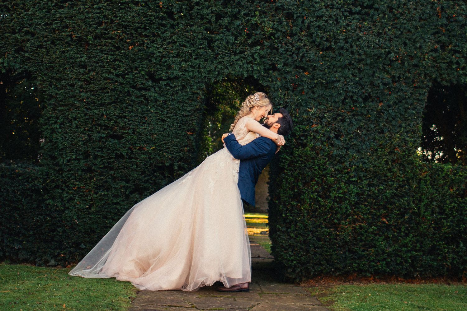 Romantic dance sequence captured against dark garden backdrop at wedding reception.