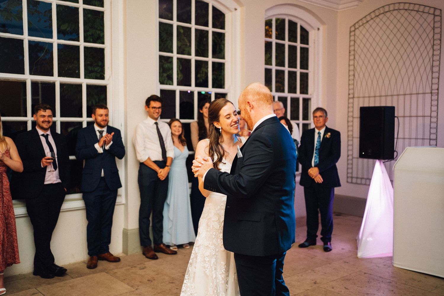 Elegant white wedding venue interior with arched windows and decorative lattice details.