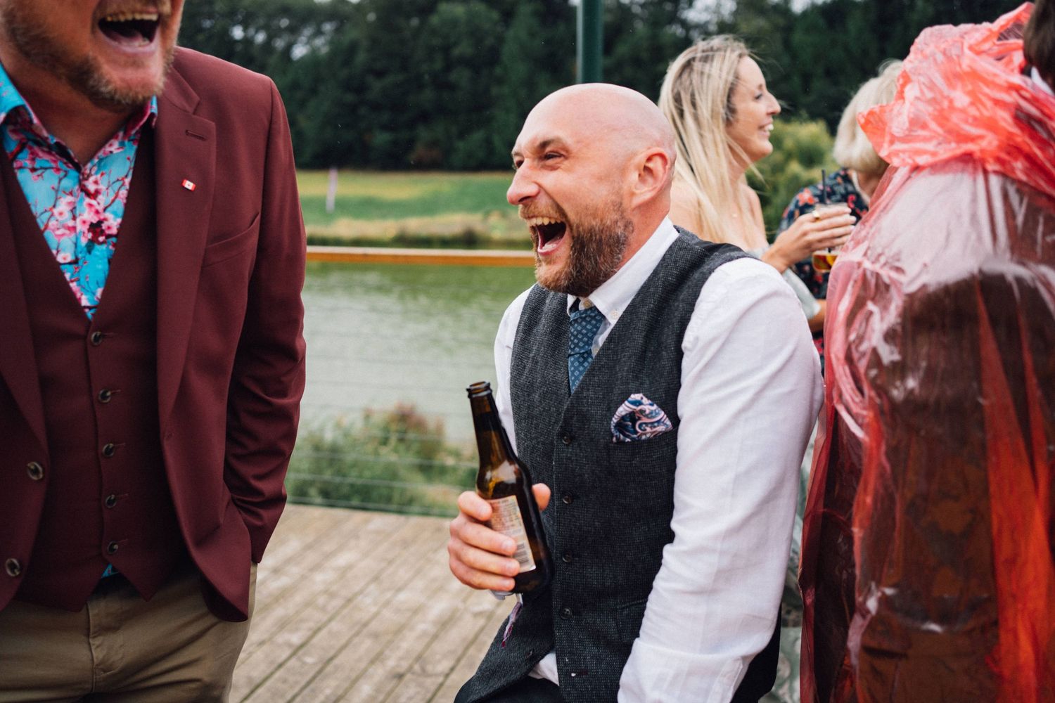 Wedding guests share laughter during an outdoor celebration.