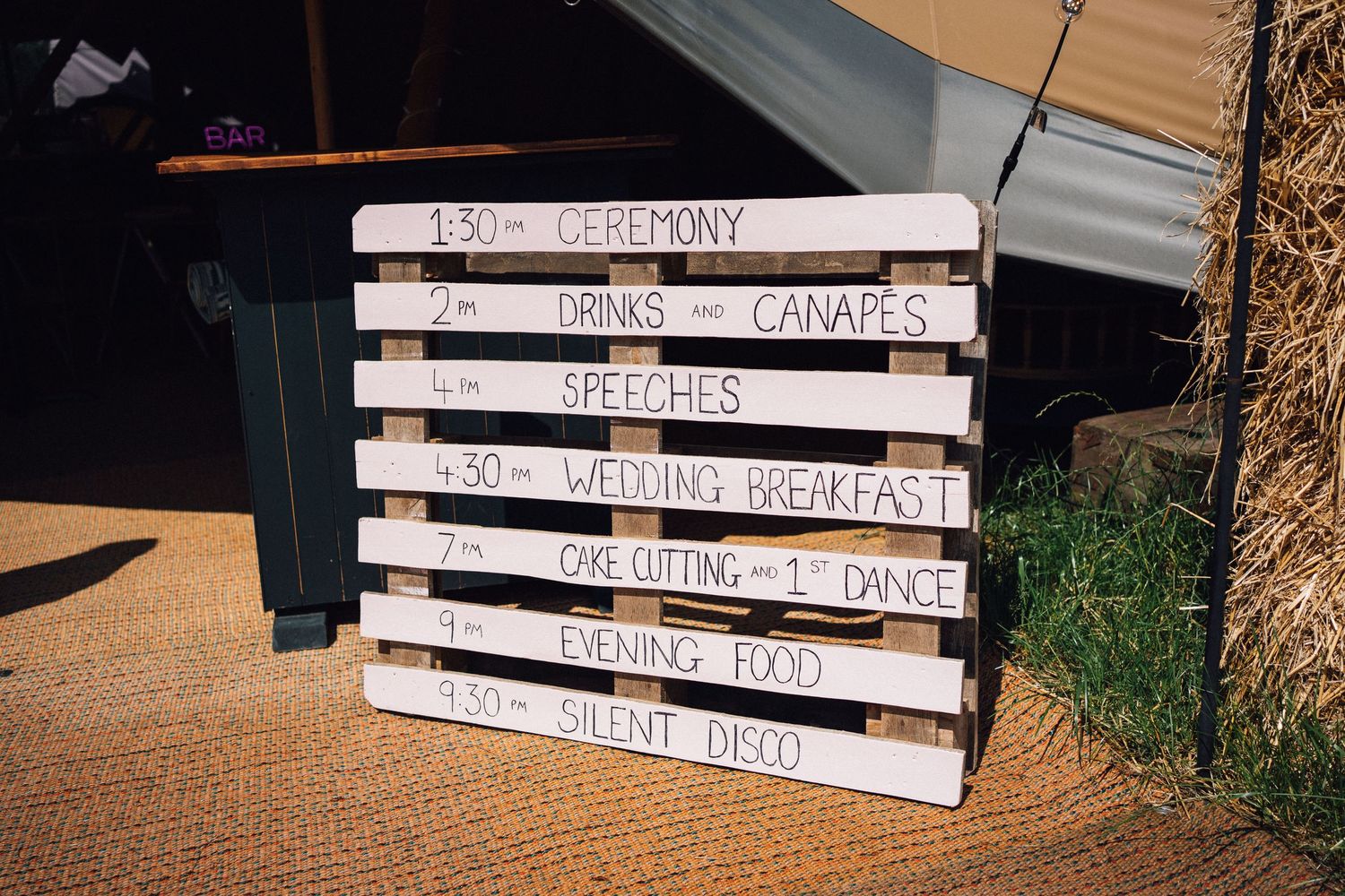 Rustic wooden directional signs for a wedding display ceremony and reception details against a natural backdrop.