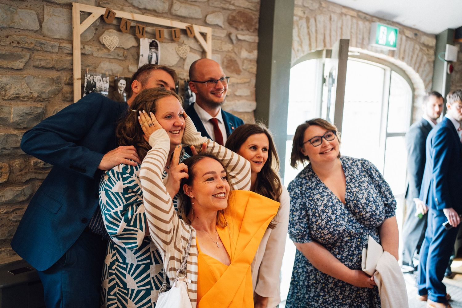 Group of wedding guests sharing laughs during reception celebration.