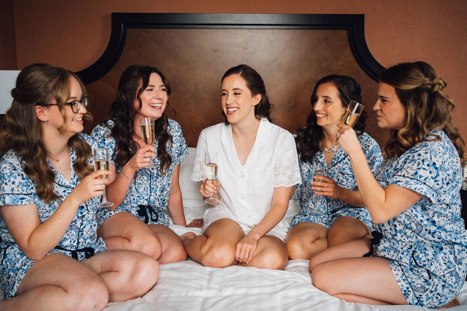 Wedding party members in matching blue floral robes relaxing before the ceremony.