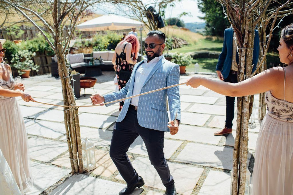 People dancing and celebrating on an outdoor stone patio during a festive gathering.