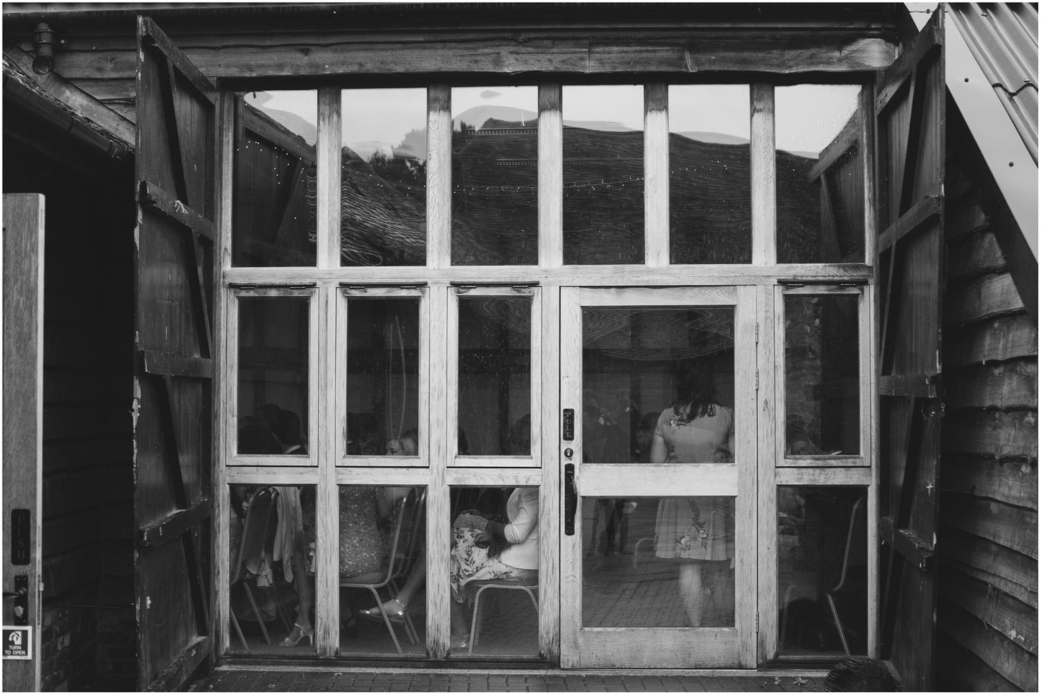 Exterior view of a rustic white building with multiple window panes.