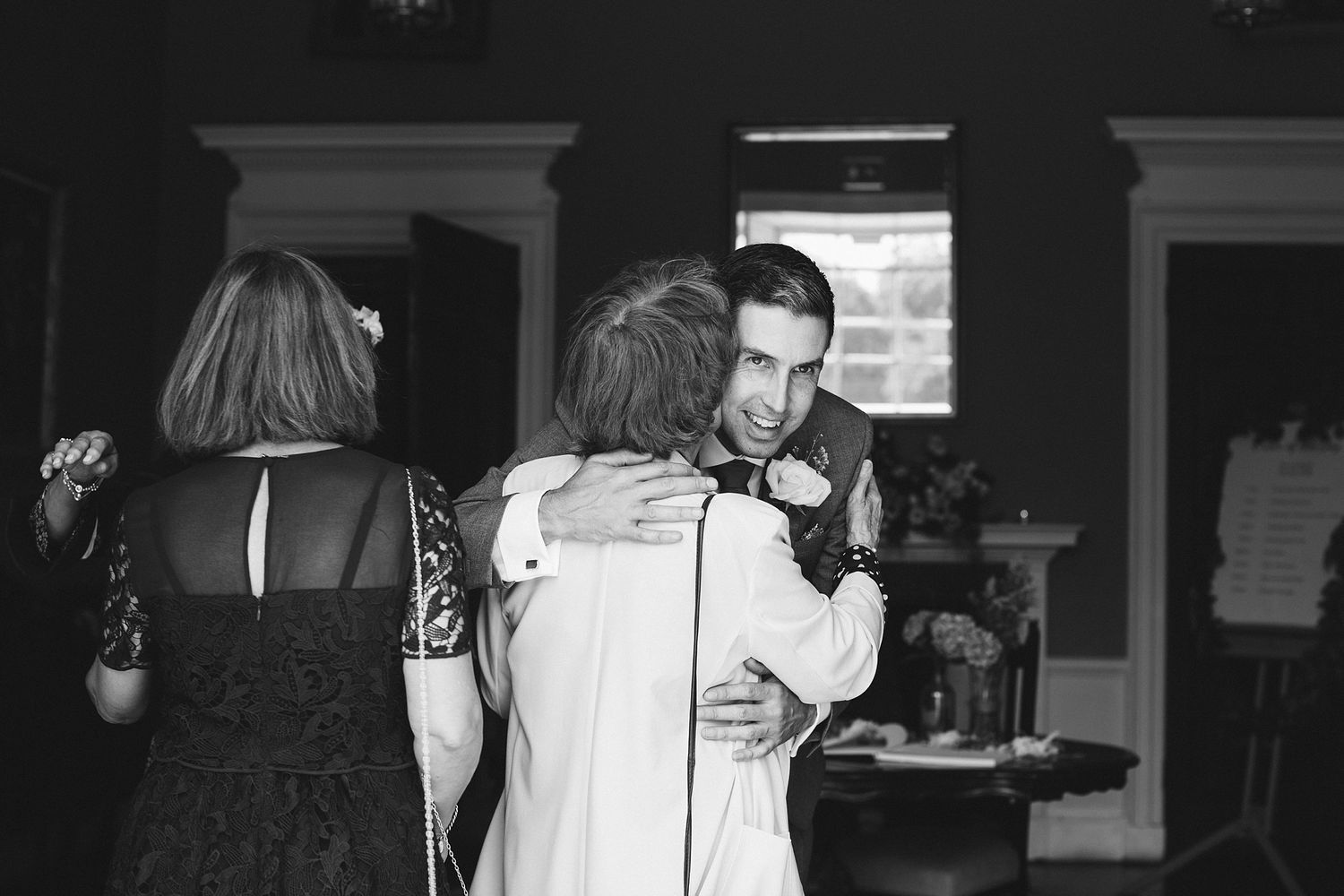 Wedding guests in formal attire share candid moments during a reception celebration.