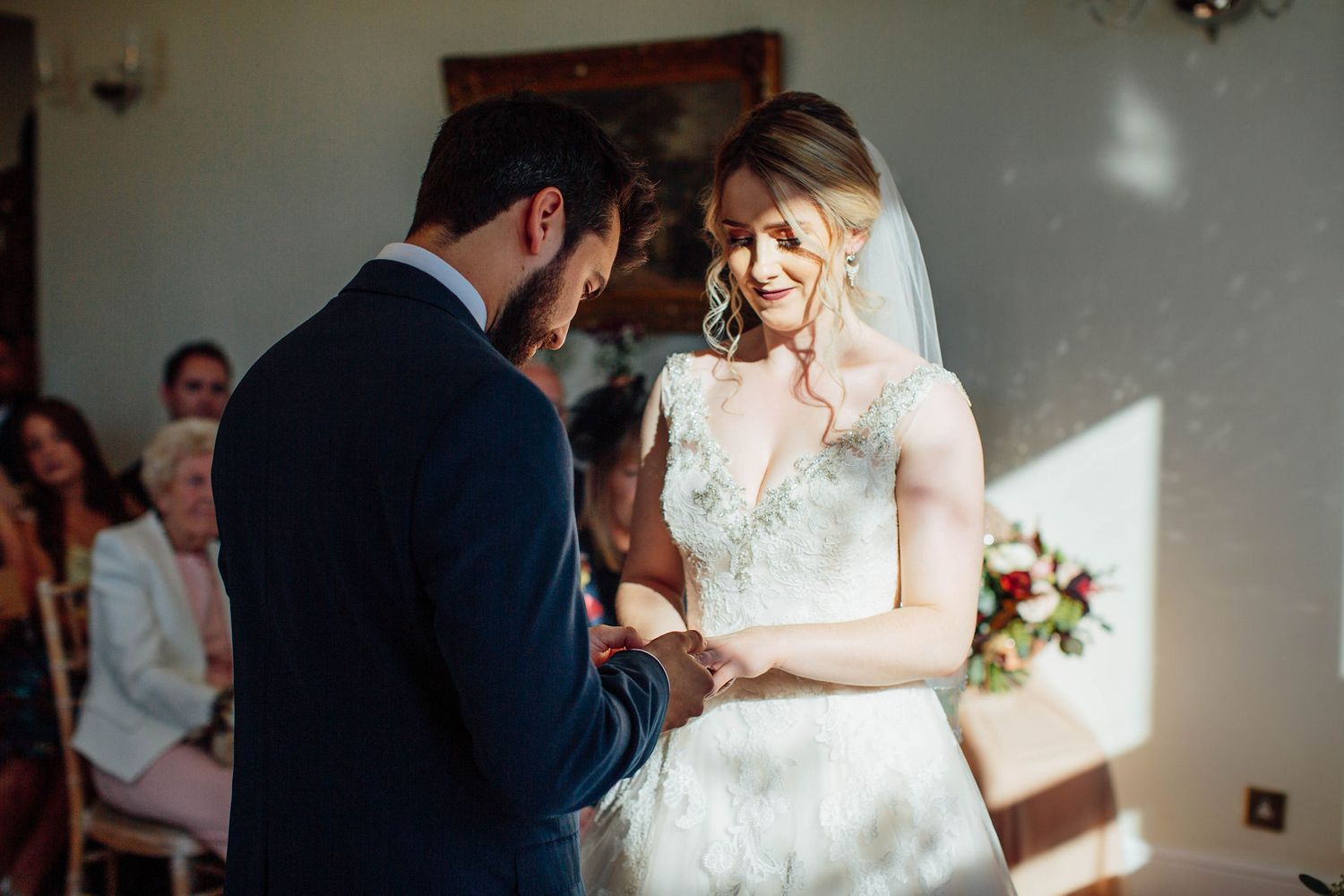 Tender wedding ceremony moment captured in a light-filled room with classic decor.