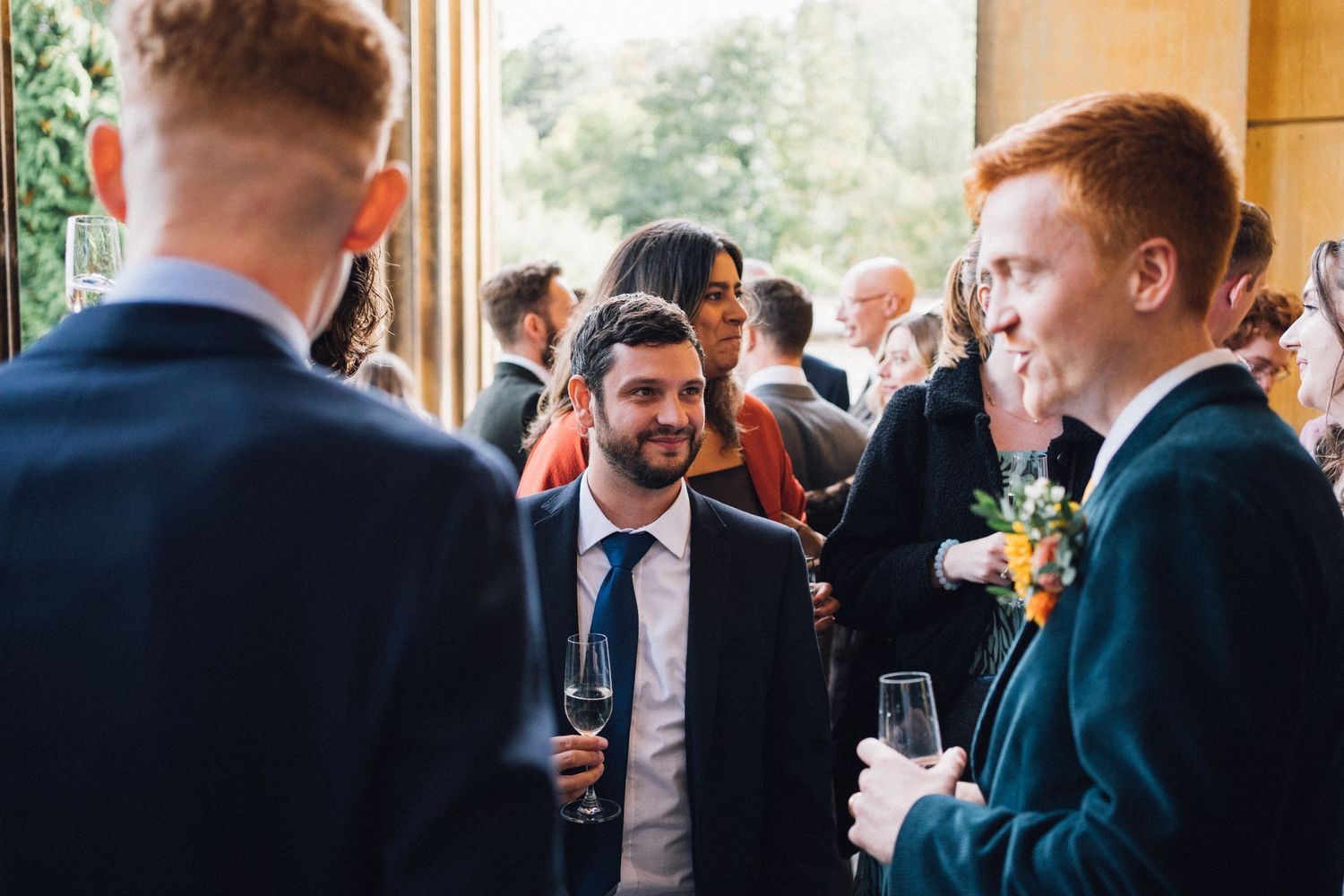 Guests engage in lively conversation during an elegant indoor reception or networking event.