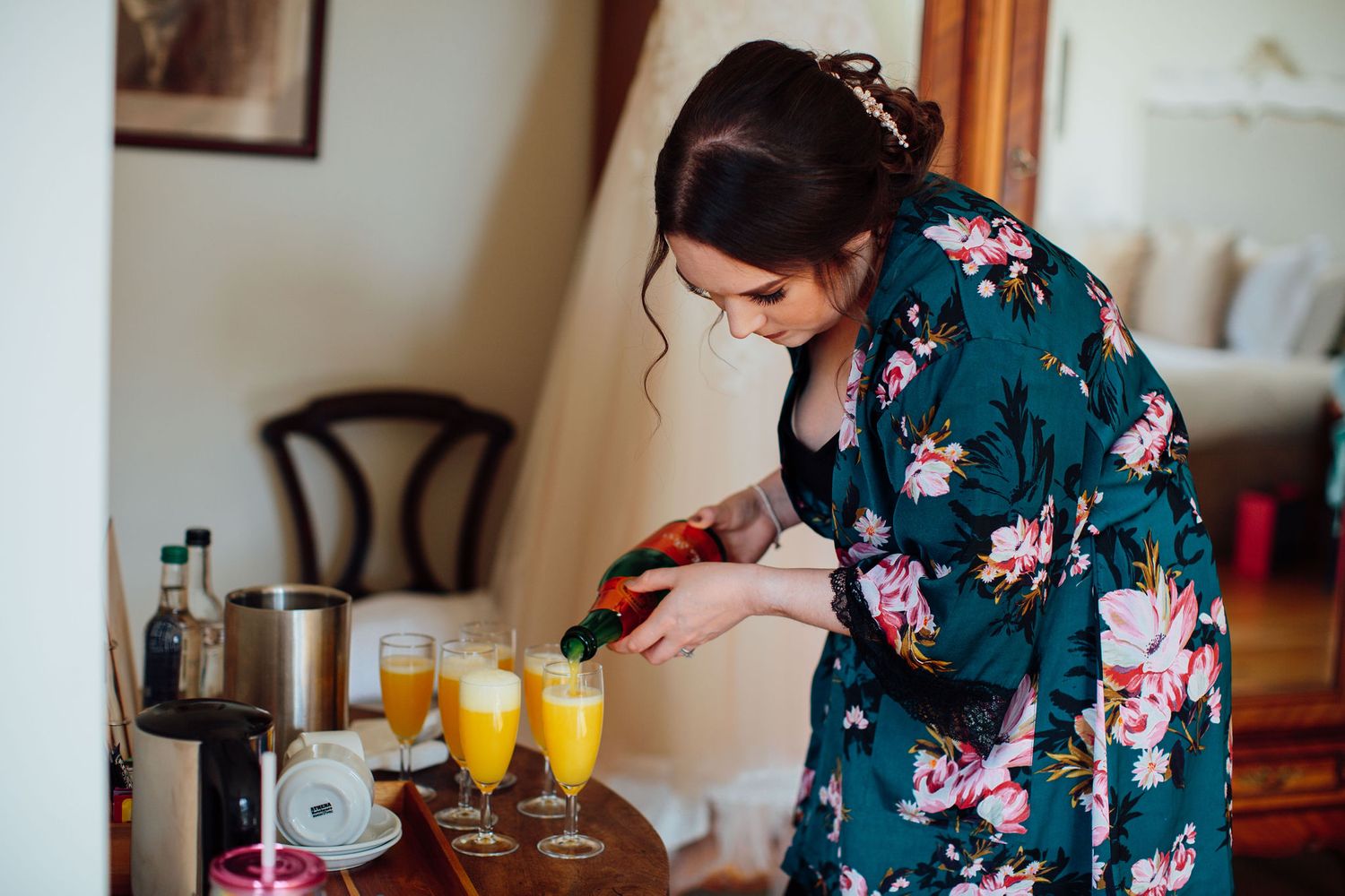 Getting ready scene with floral robes and mimosas on a wedding morning.