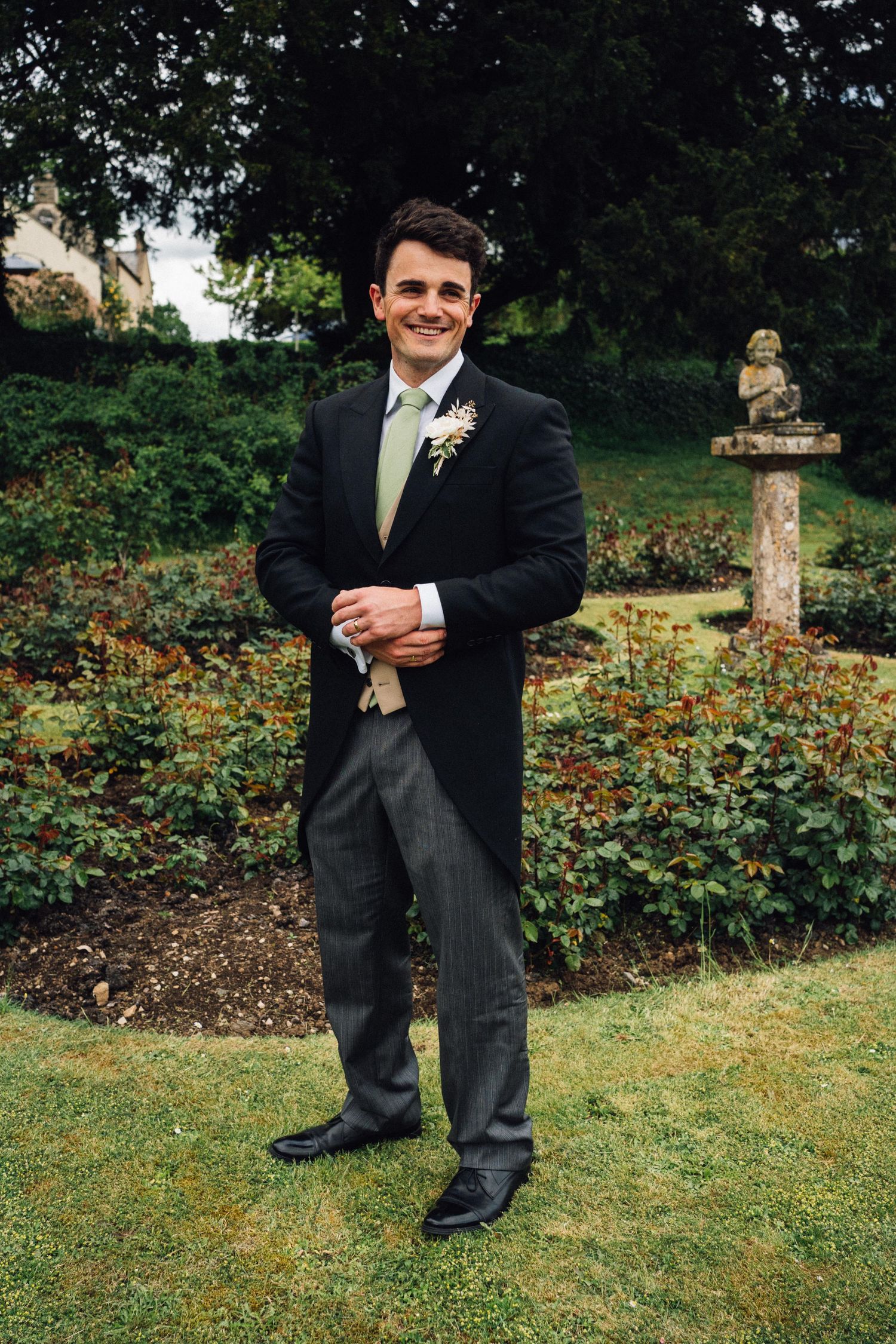 Formal wedding attire details shown against garden backdrop with roses.