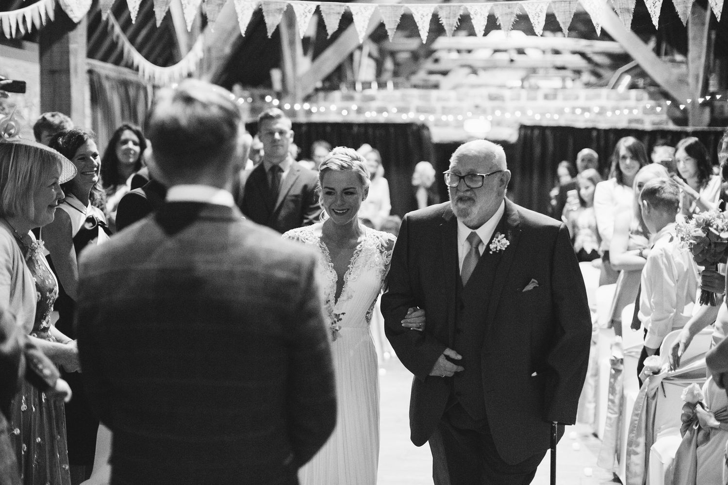Wedding celebration in a rustic venue with exposed brick walls and hanging decorations.