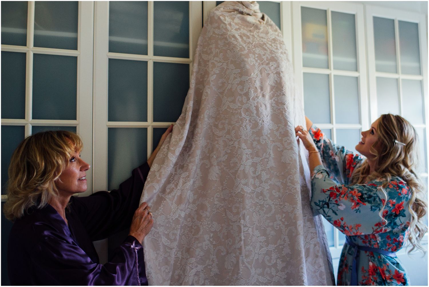 Two people interacting near a window in a casual indoor setting.