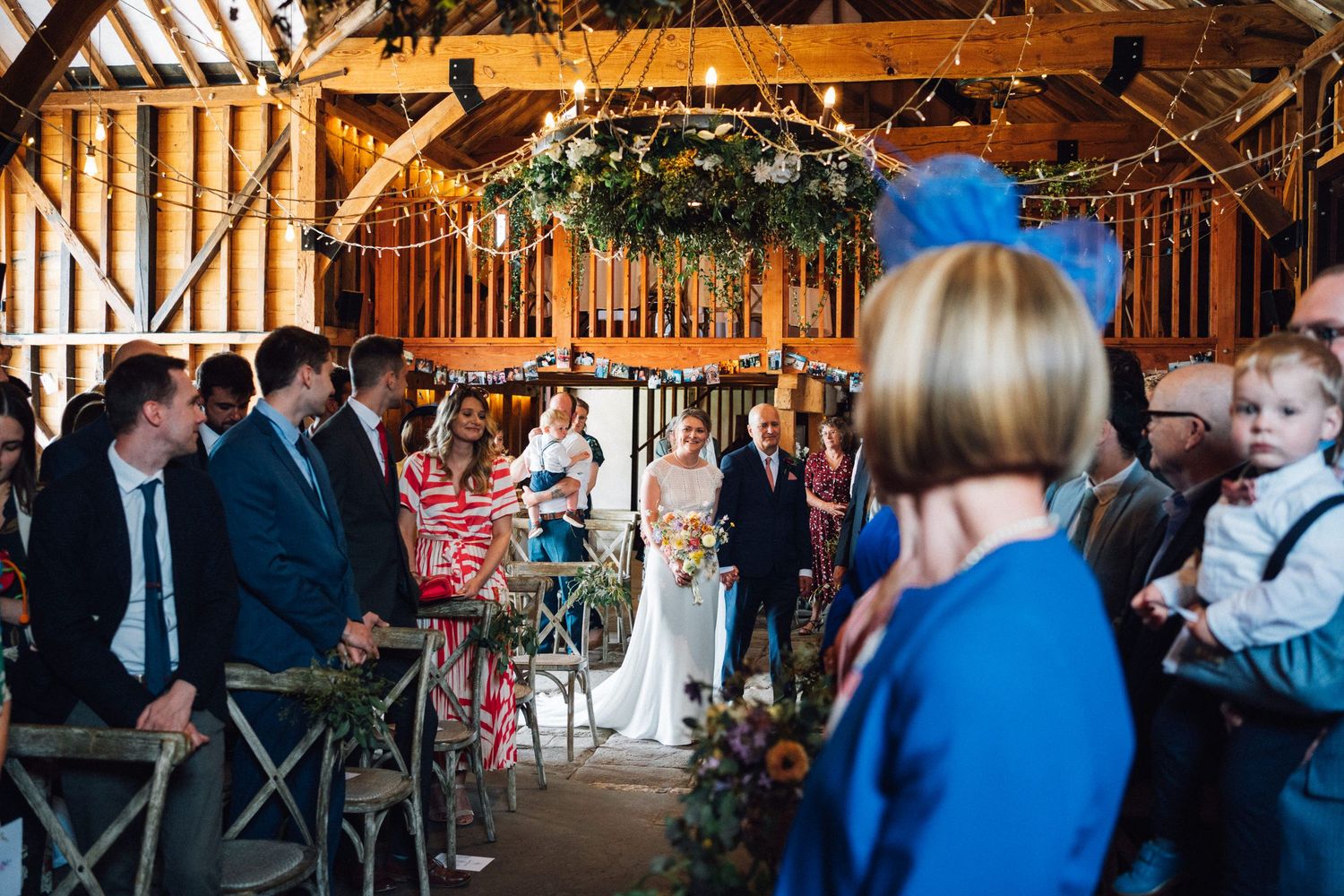 Wedding reception in a rustic barn venue with exposed beams and string lights.