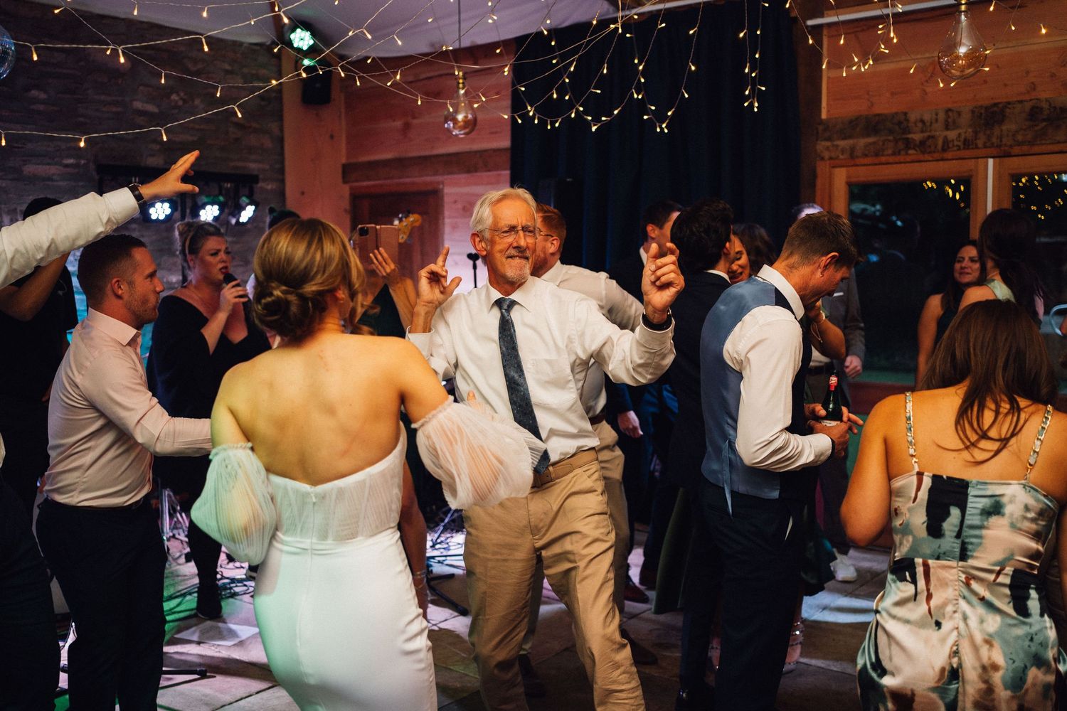 Guests enjoying a festive dance party with string lights glowing overhead.