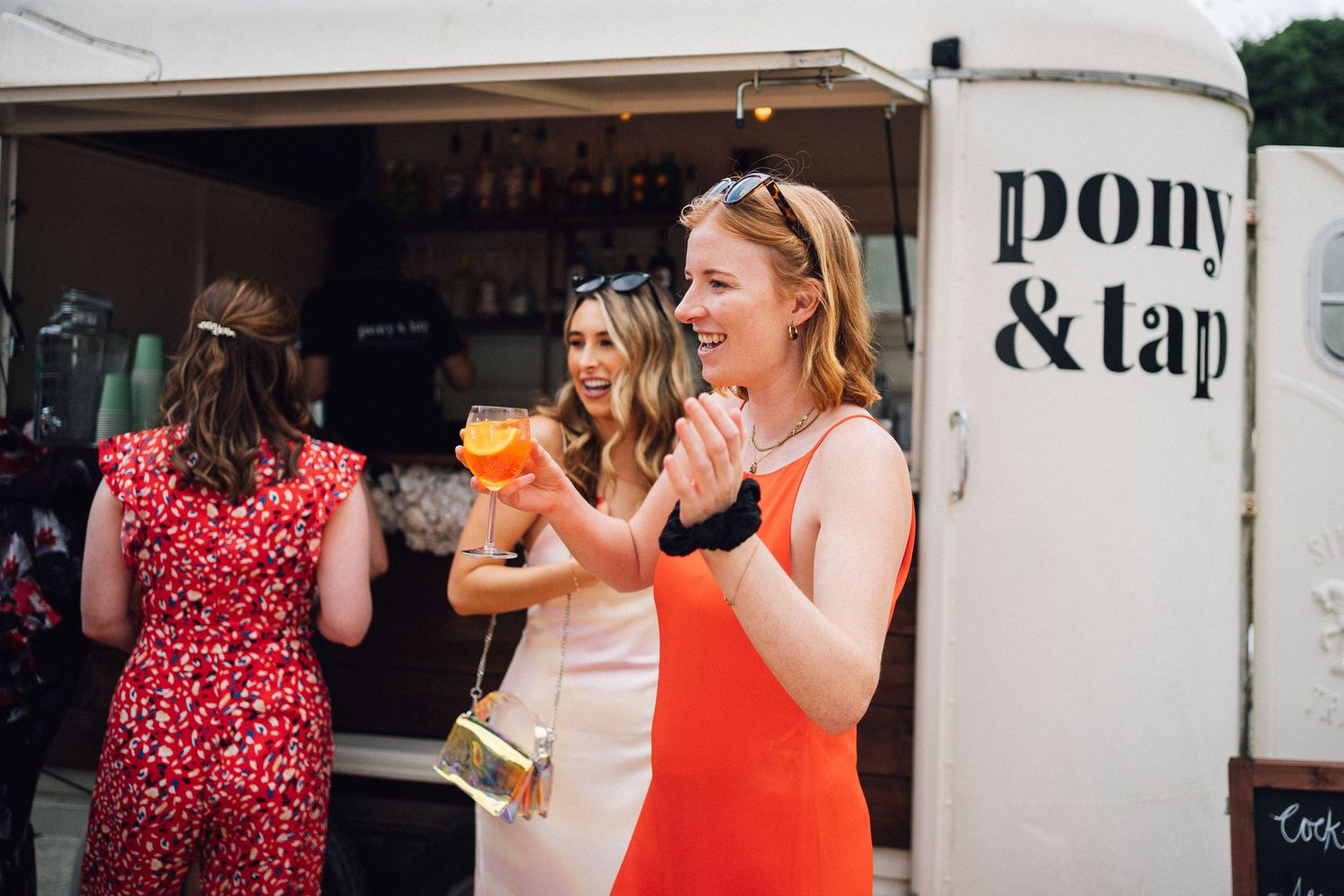 Wedding guests mingling and socializing at an outdoor summer celebration.
