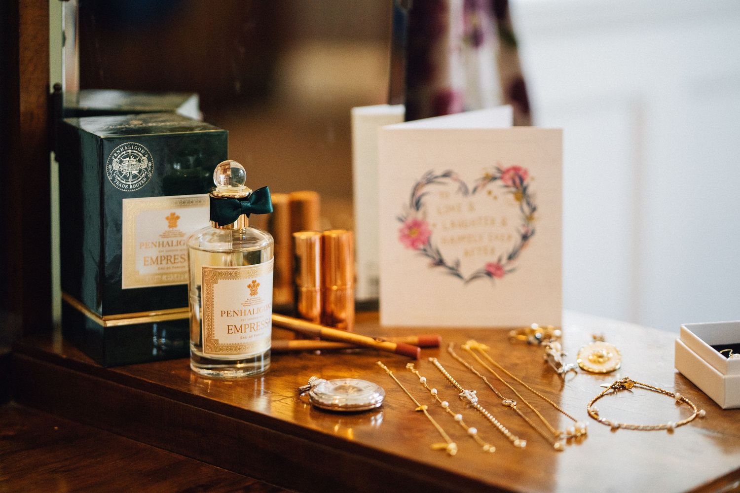 Wedding details including rings, cards, and decorative items arranged on a wooden surface.