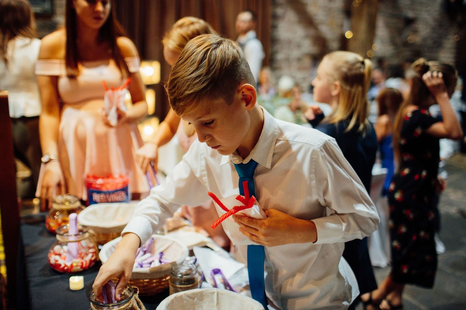 Children playing with sparklers at an evening wedding reception.