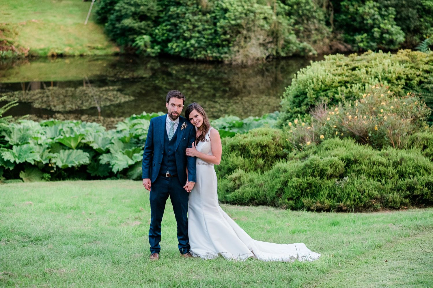 Romantic wedding photos taken on rolling green hills with natural landscaping.