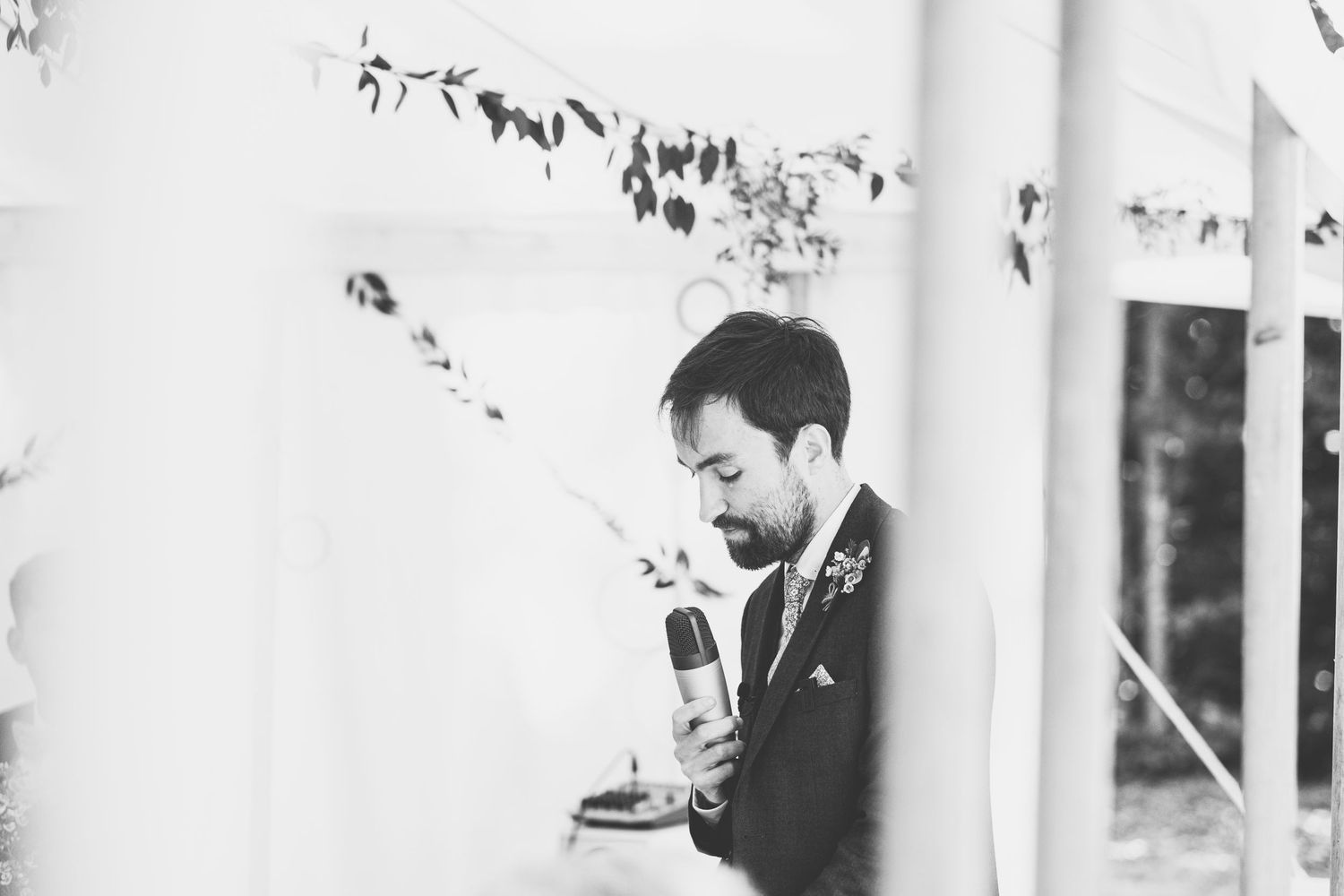 Black and white photo of wedding guests during reception speeches.