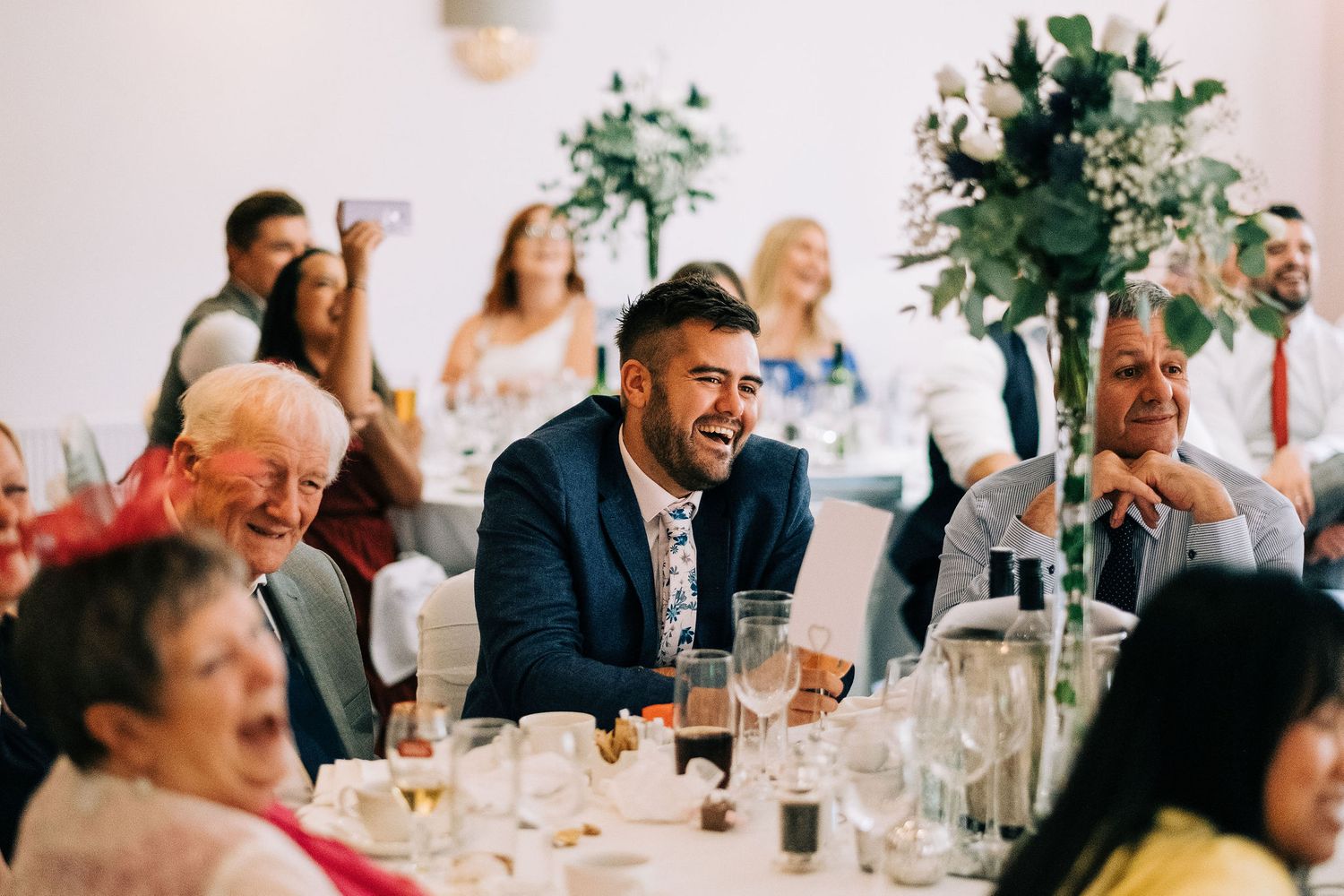 Wedding reception candid moments captured as guests dine and socialize at elegant tables.