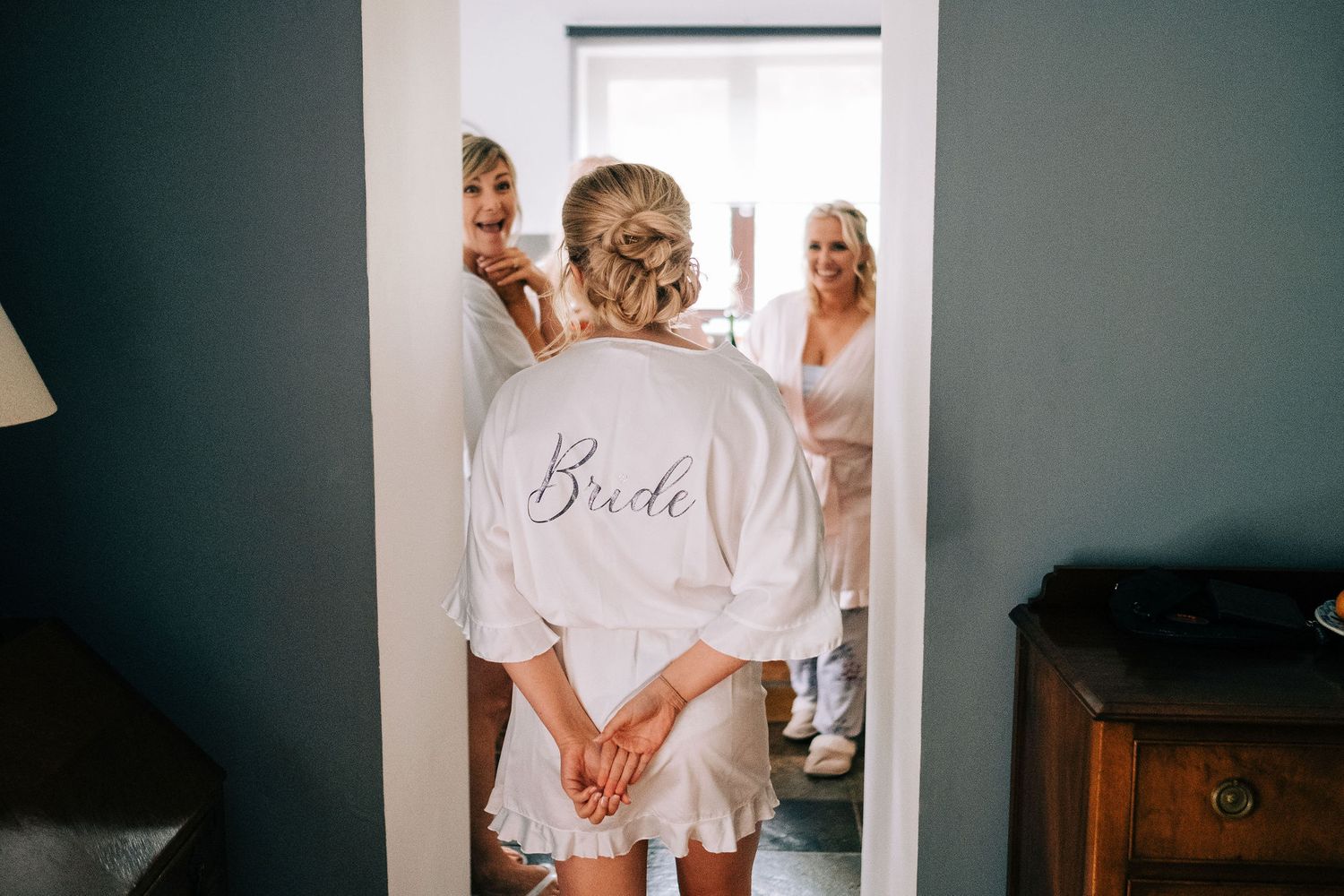 Getting ready scene with white robes in a bridal preparation room.