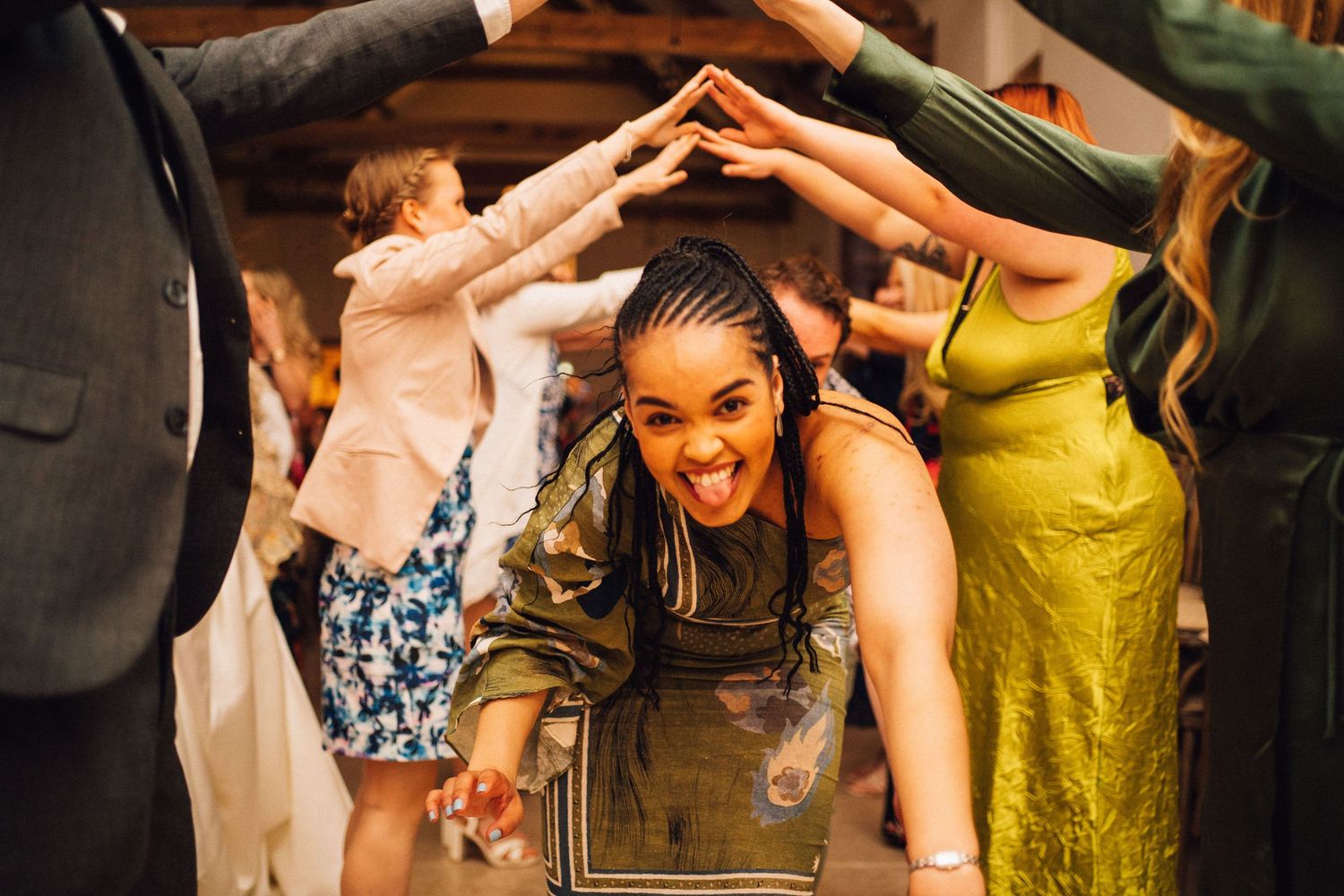 People dancing together in formal attire at a wedding reception with joyful expressions and movement.